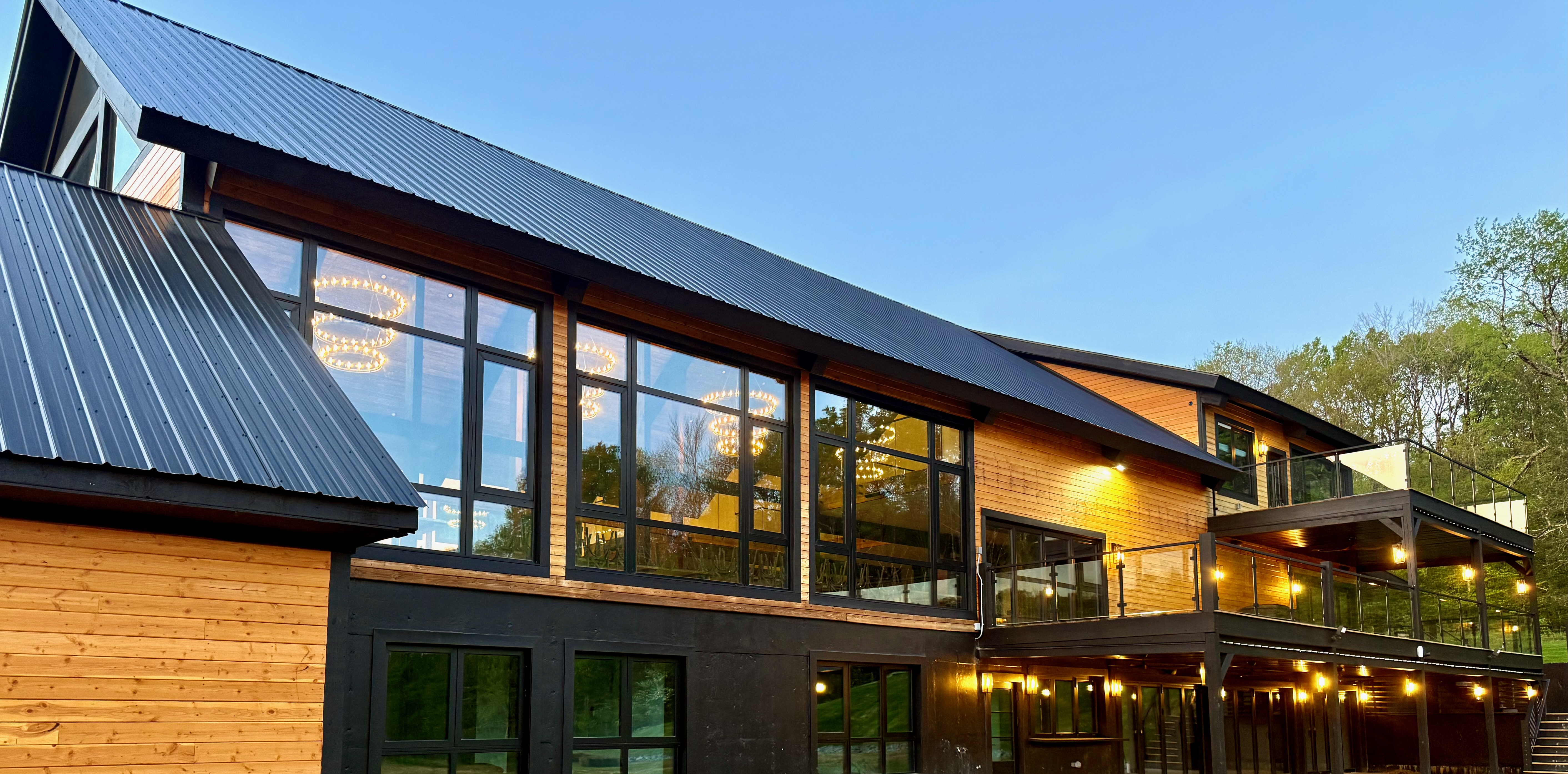 Mountain Meadows barn exterior at dusk with string lights Catskills wedding venue Long Eddy NY