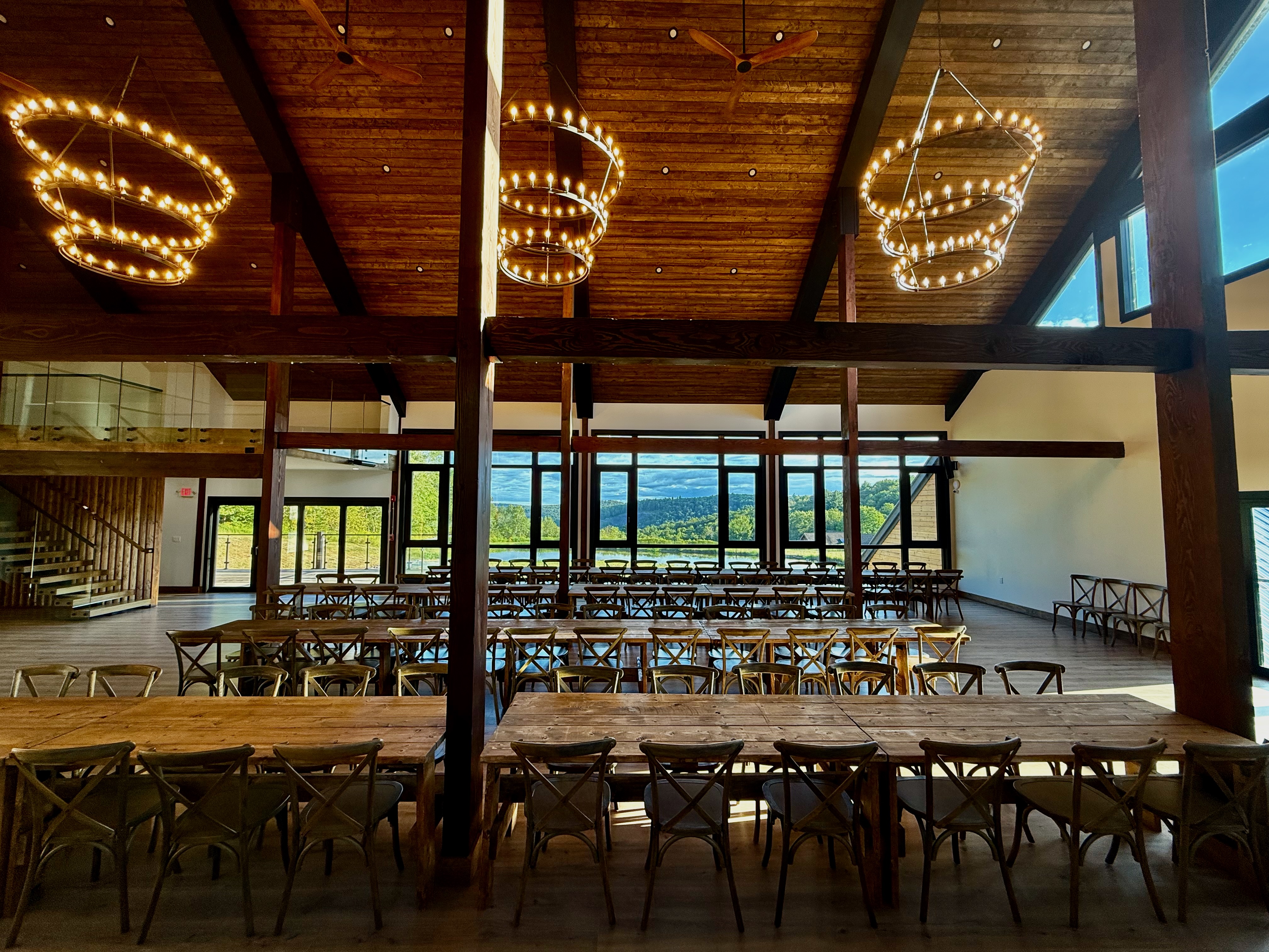 Barn wedding reception tables with chandeliers and mountain views at Mountain Meadows Catskills venue