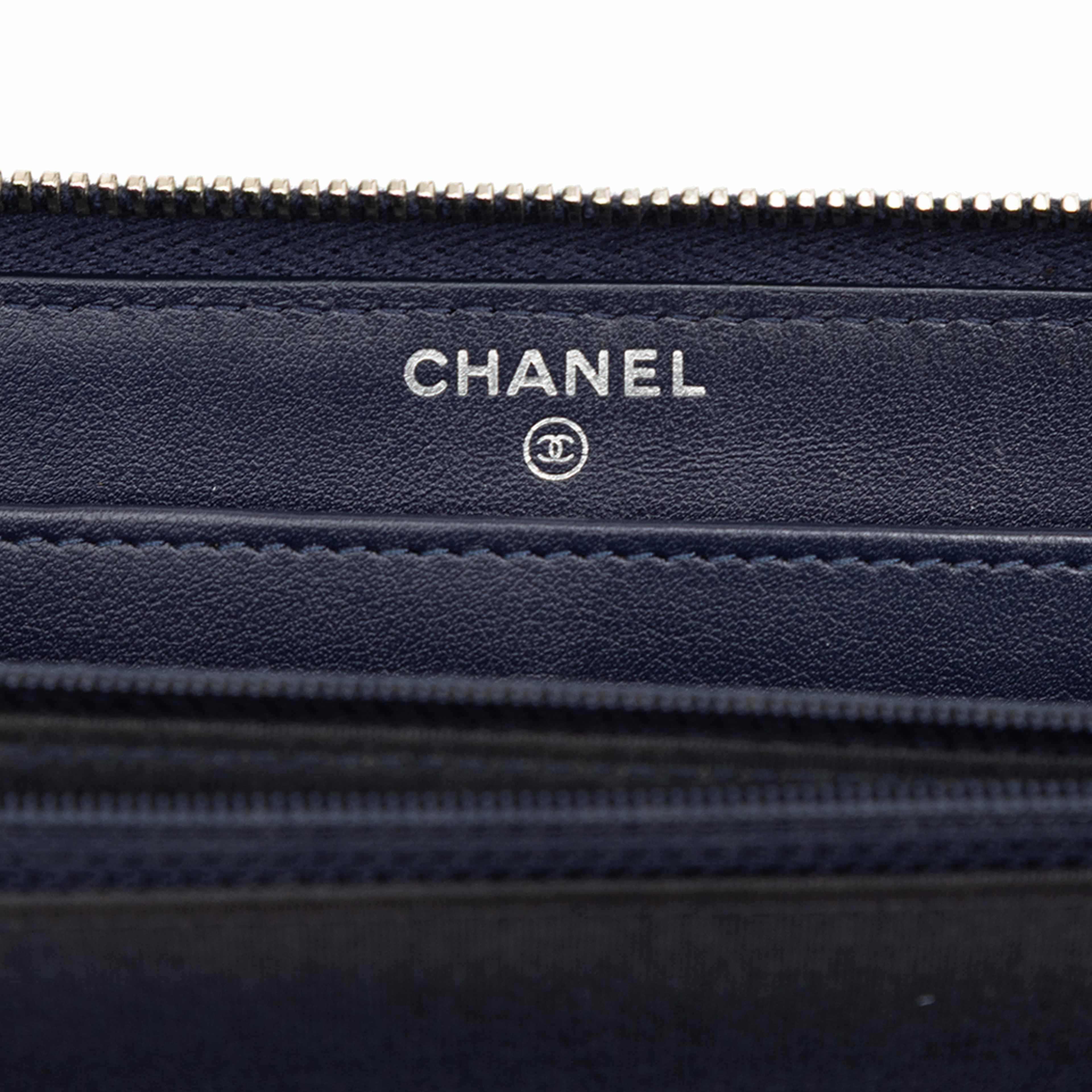 Chanel Camellia Embossed Zip Around Long Wallet, från Luxclusif, i färgen navy. Klicka för att öppna bilden i stort format