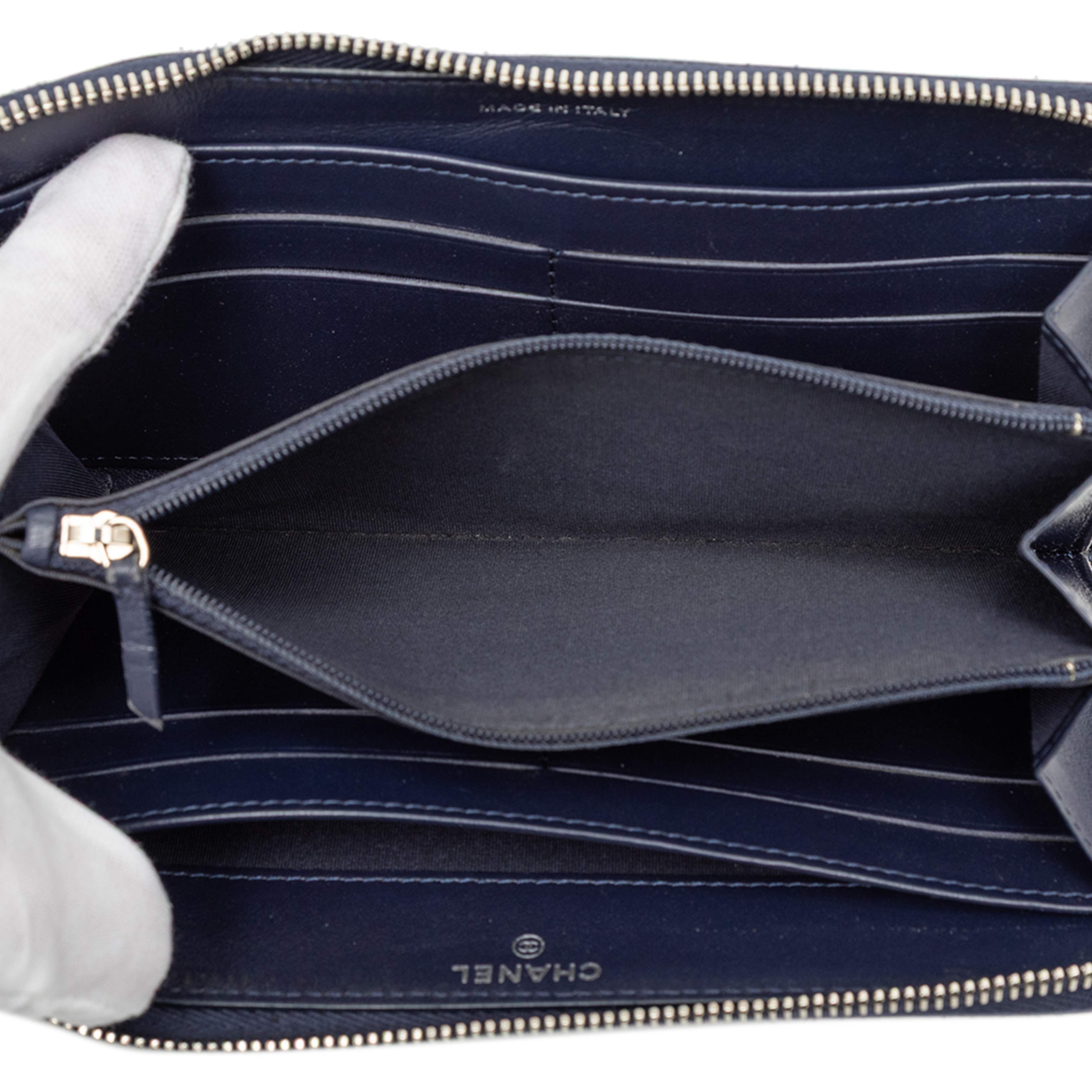 Chanel Camellia Embossed Zip Around Long Wallet, från Luxclusif, i färgen navy. Klicka för att öppna bilden i stort format