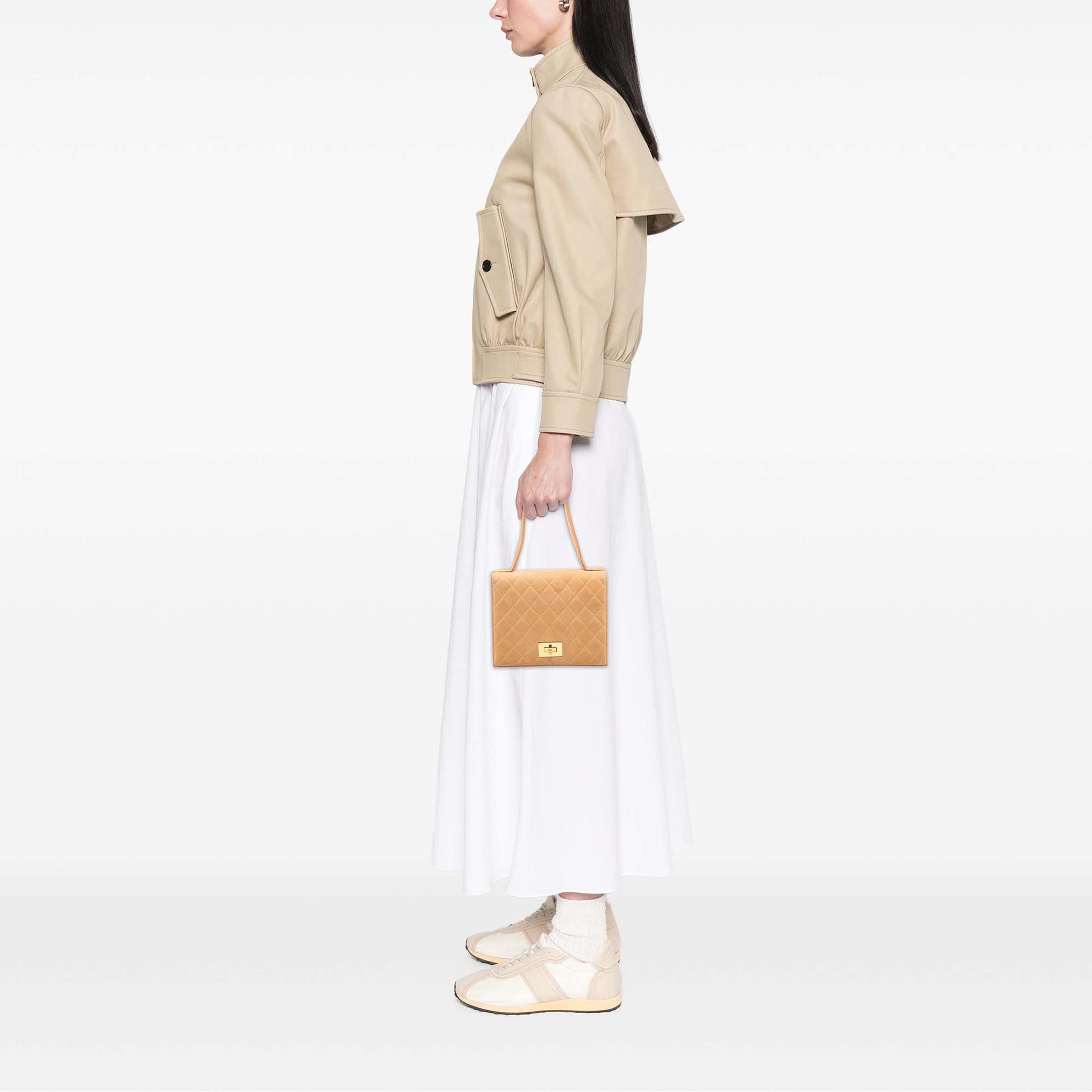 Chanel Quilted Suede Rita Flap, från Luxclusif, i färgen beige. Klicka för att öppna bilden i stort format