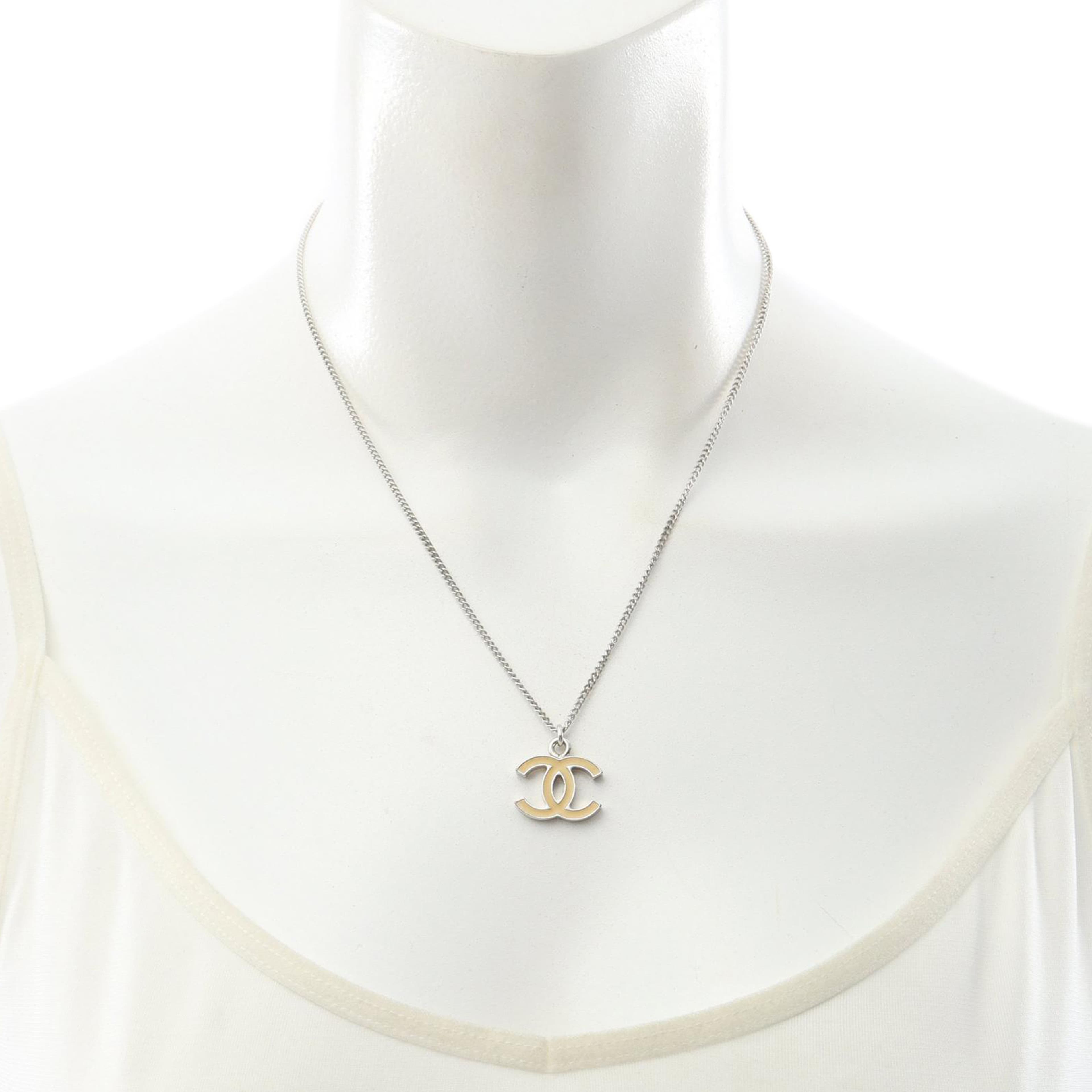 Chanel Cc Brass Enamel Pendant Necklace, från Luxclusif, i färgen beige. Klicka för att öppna bilden i stort format