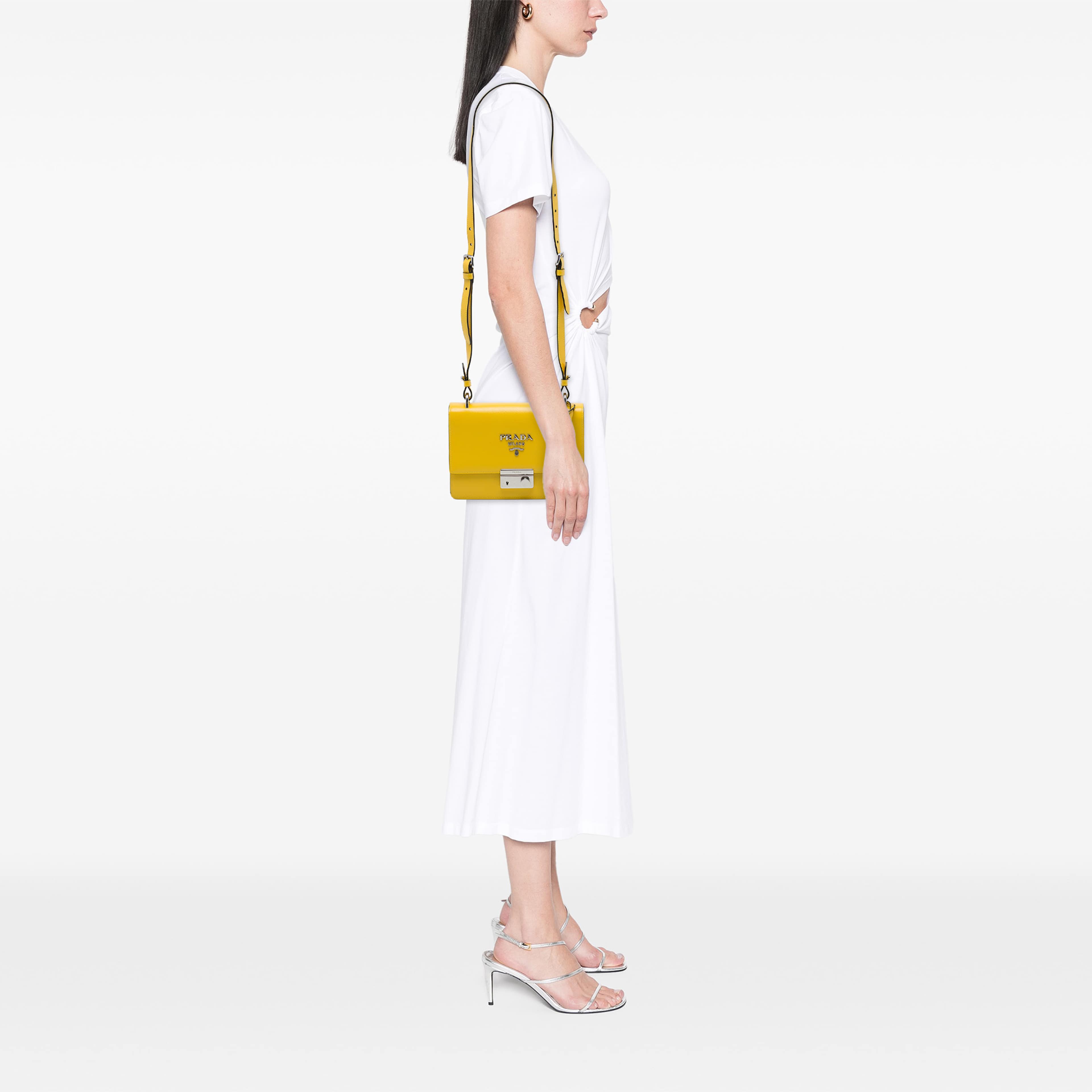 Prada Saffiano Lux Sound Lock Crossbody, från Luxclusif, i färgen gul. Klicka för att öppna bilden i stort format