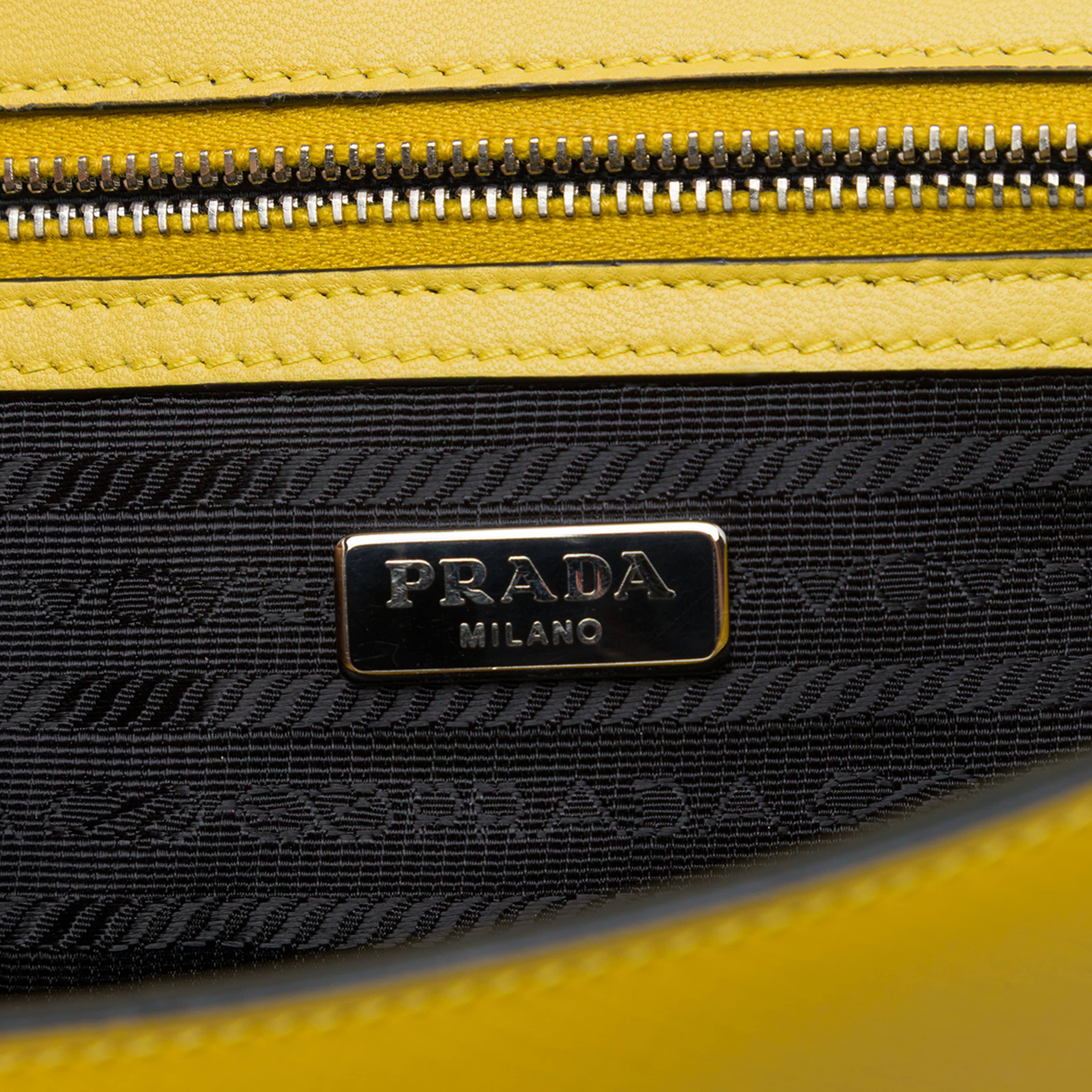 Prada Saffiano Lux Sound Lock Crossbody, från Luxclusif, i färgen gul. Klicka för att öppna bilden i stort format