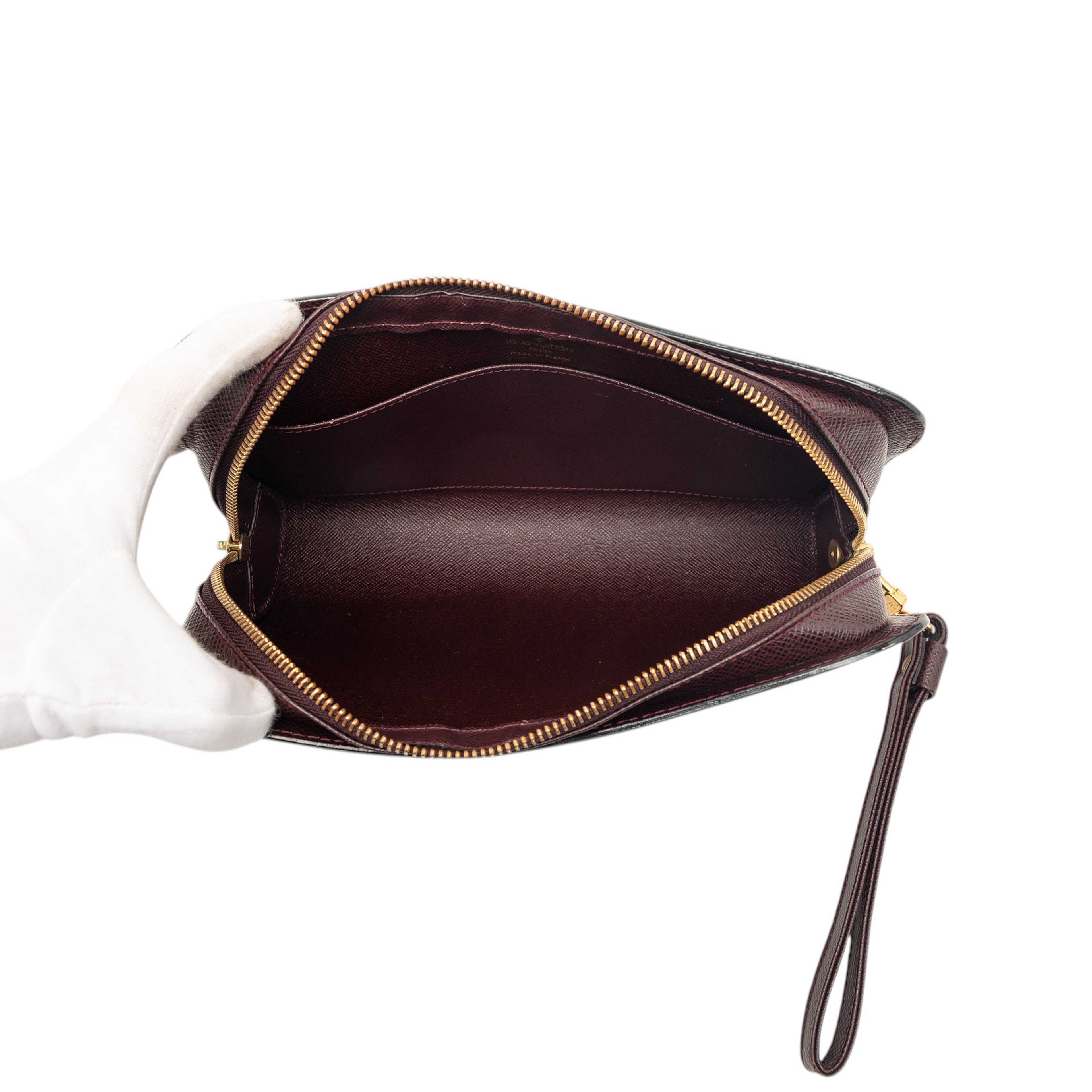 Louis Vuitton Taiga Pochette Baikal, från Luxclusif, i färgen bordeaux. Klicka för att öppna bilden i stort format