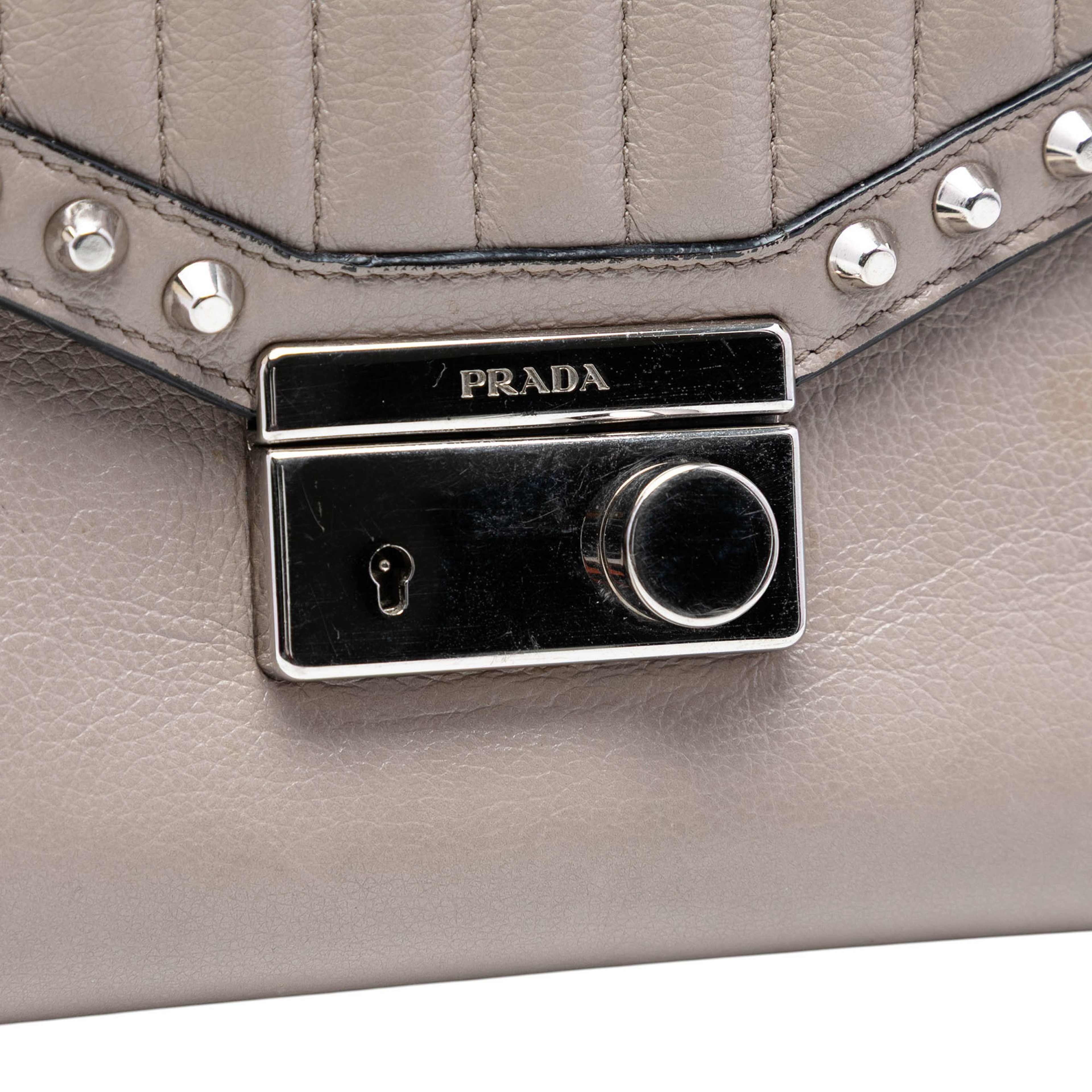 Prada Studded Glace Calf Sound Lock Crossbody, från Luxclusif, i färgen grå. Klicka för att öppna bilden i stort format
