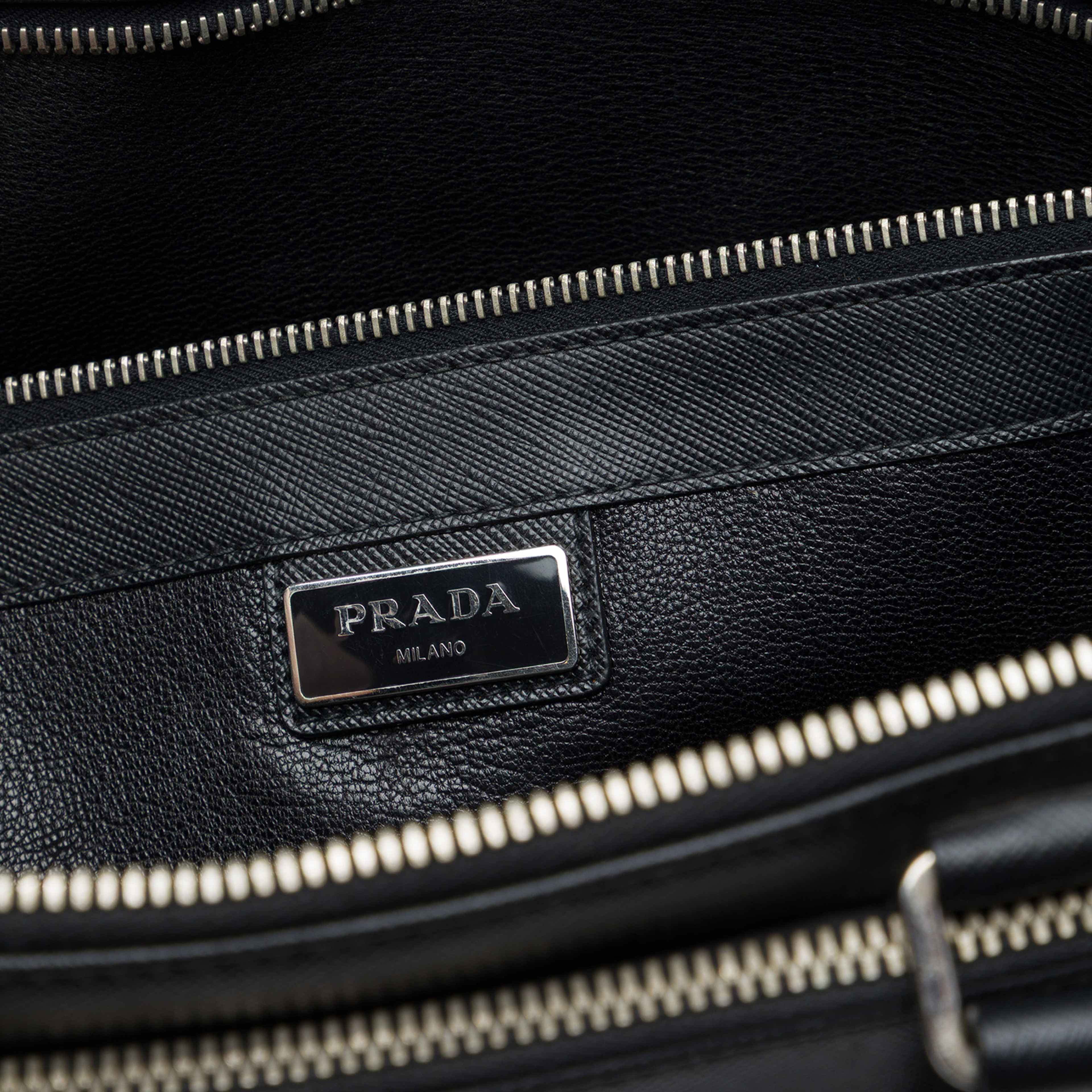 Prada Saffiano Cuir Travel Front Zip Pocket Briefcase, från Luxclusif, i färgen svart. Klicka för att öppna bilden i stort format