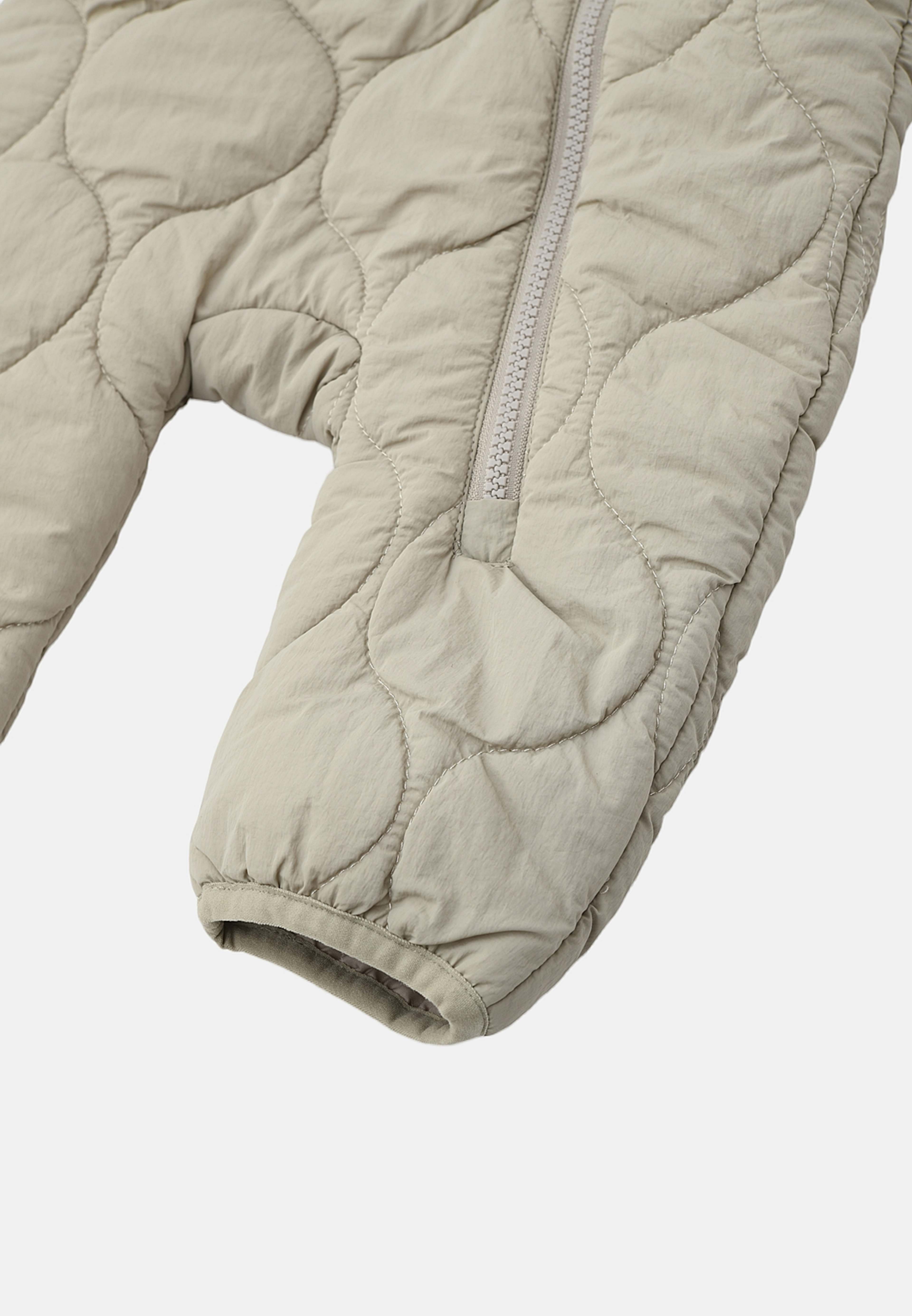 Quiltad overall BONNIE, från RIKIKI, i färgen Beige. Klicka för att öppna bilden i stort format