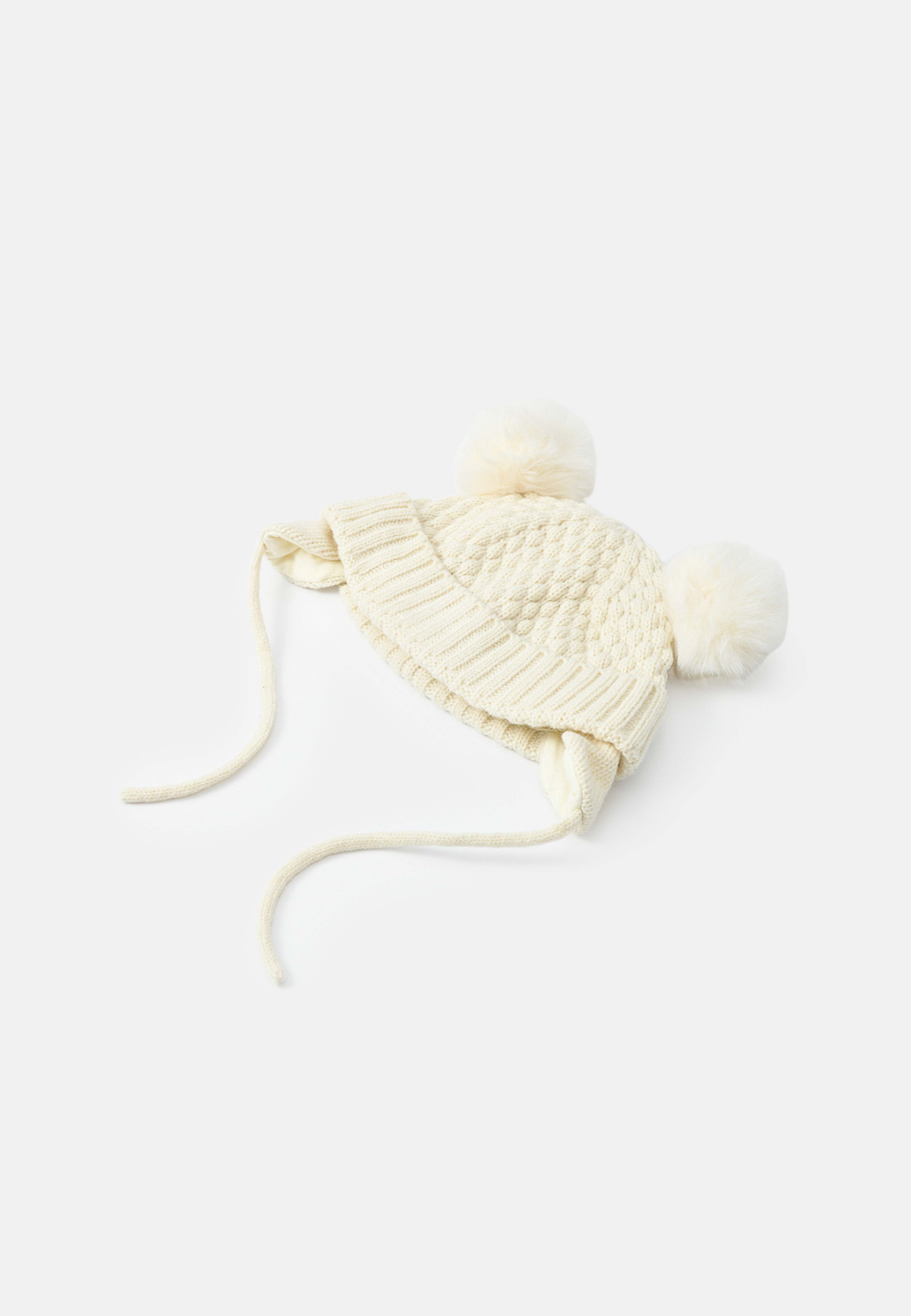 Stickad mössa med pälsbollar CILLA, från RIKIKI, i färgen White. Klicka för att öppna bilden i stort format