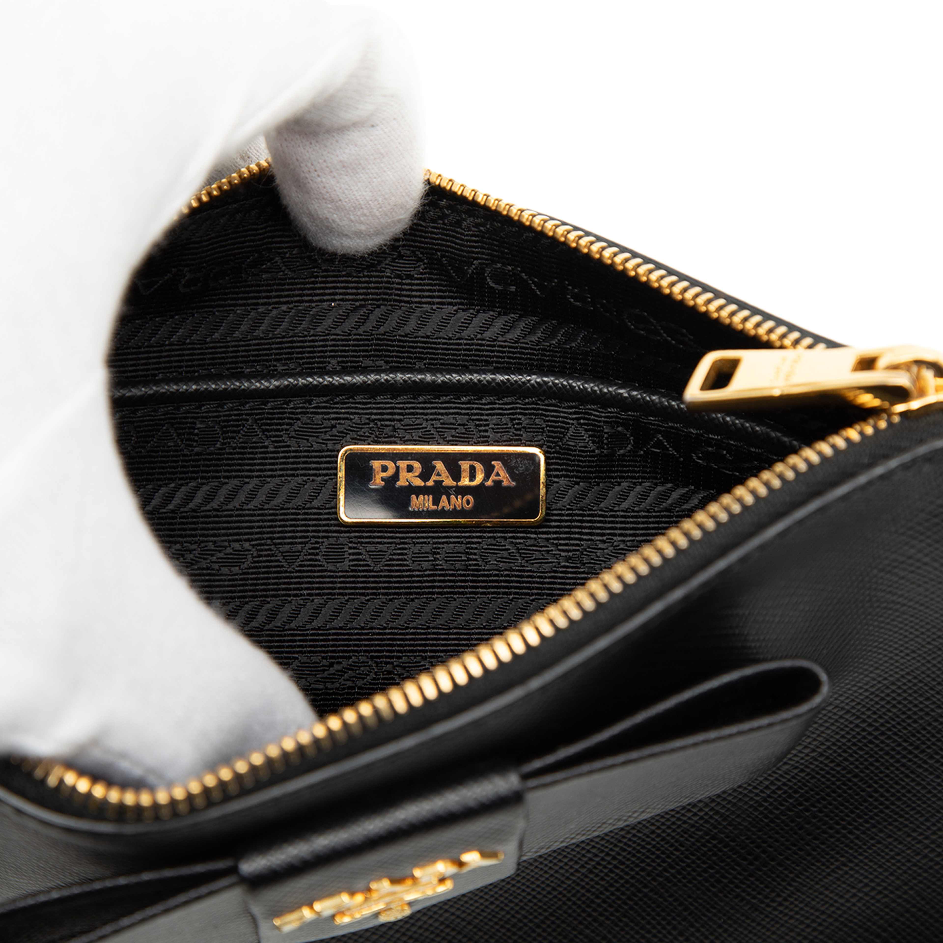 Prada Saffiano Bow Clutch, från Luxclusif, i färgen black. Klicka för att öppna bilden i stort format