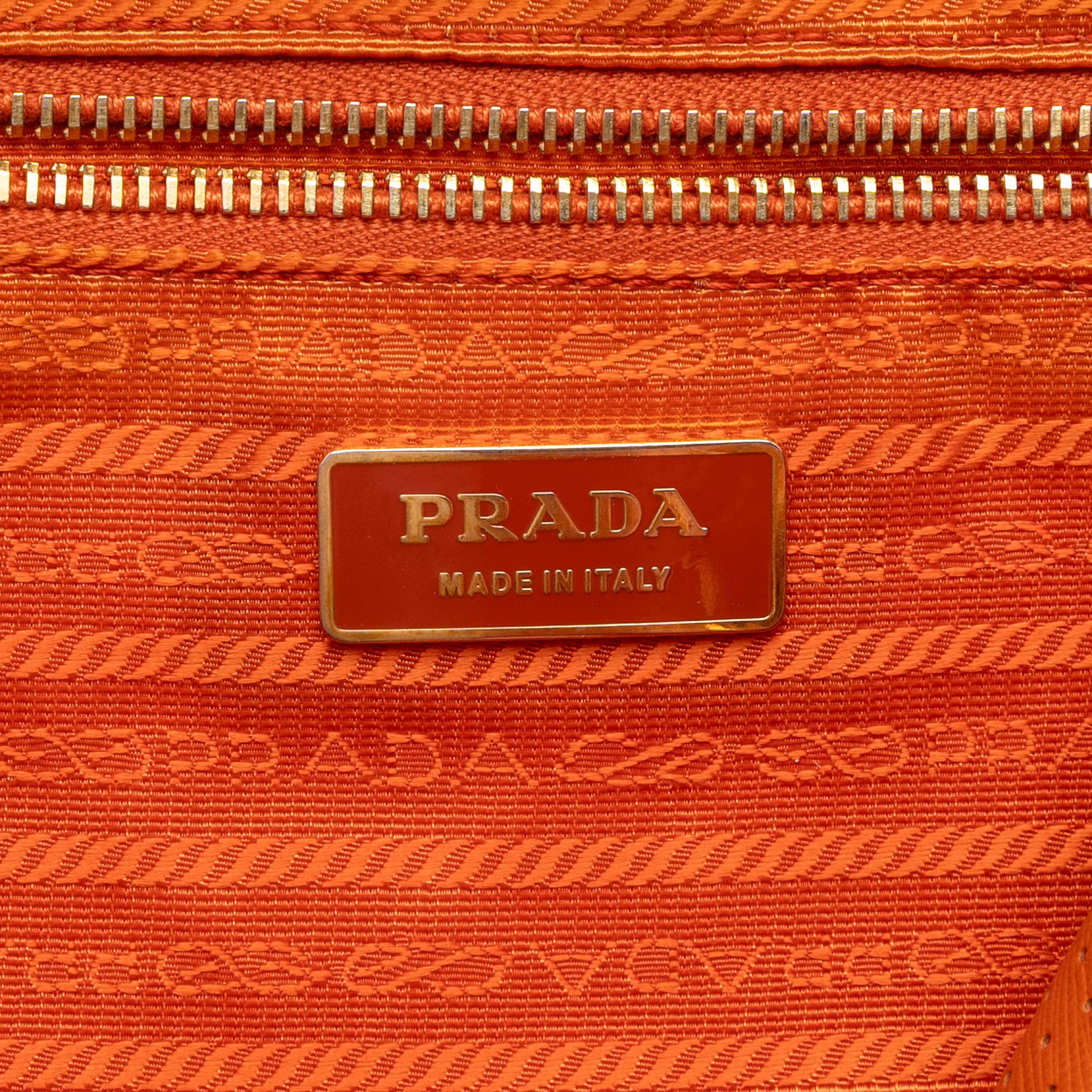 Prada Perforated Vitello Drive Leather Bauletto Top Handle Bag, från Luxclusif, i färgen dark orange. Klicka för att öppna bilden i stort format