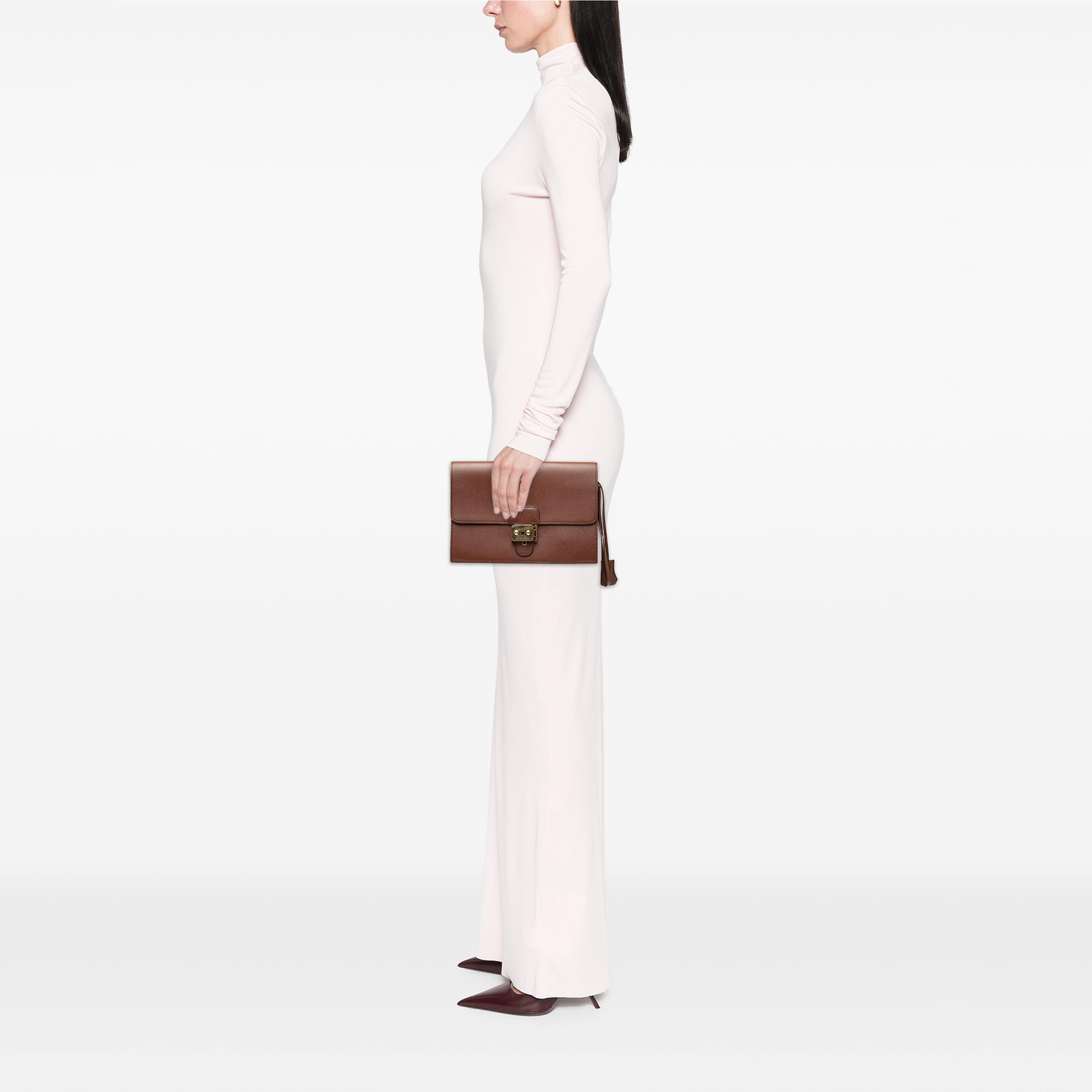 Hermès Courchevel Jet Pochette Clutch, från Luxclusif, i färgen brun. Klicka för att öppna bilden i stort format