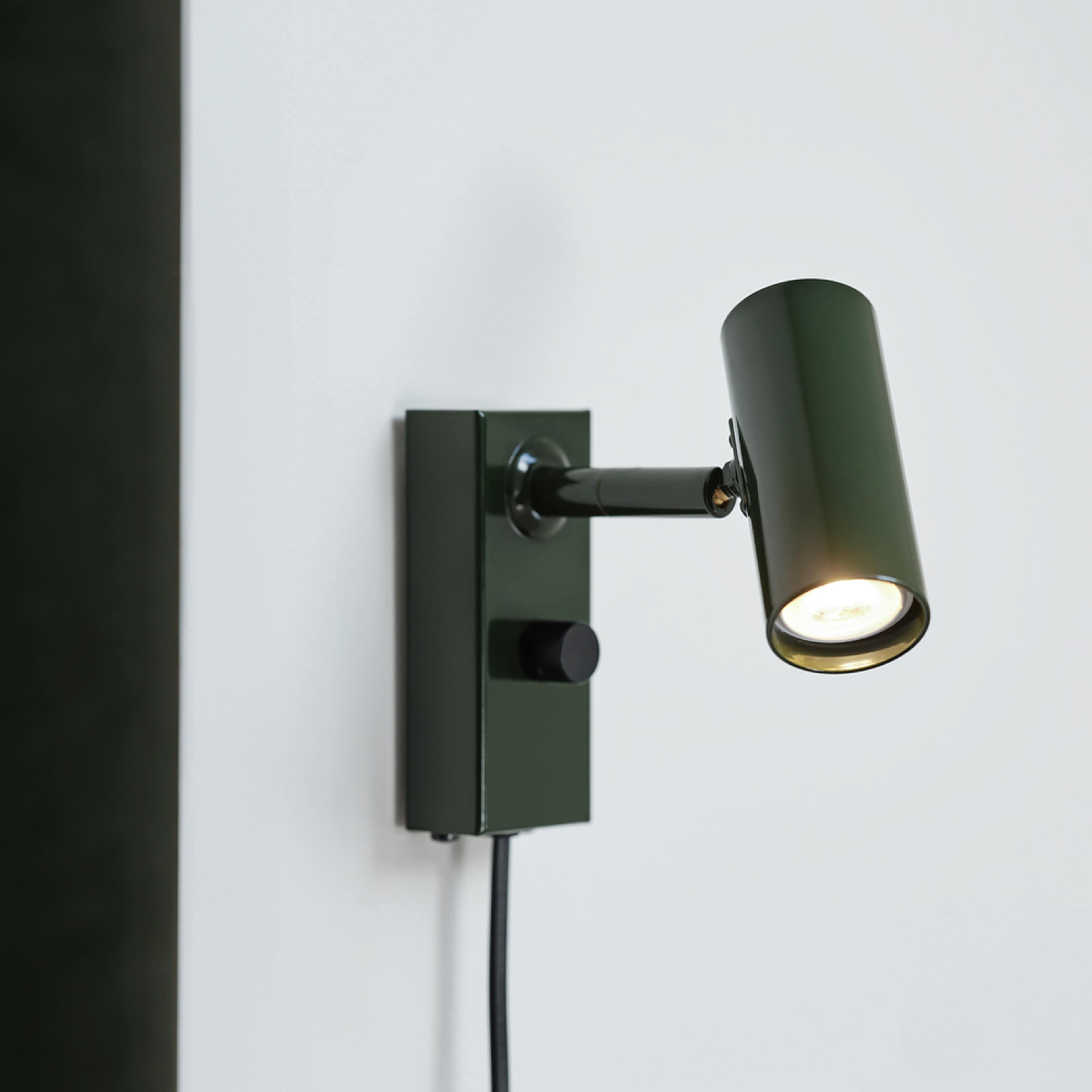 Vägglampa Cato, från Belid, i färgen blank skogsgrön/mattsvart.