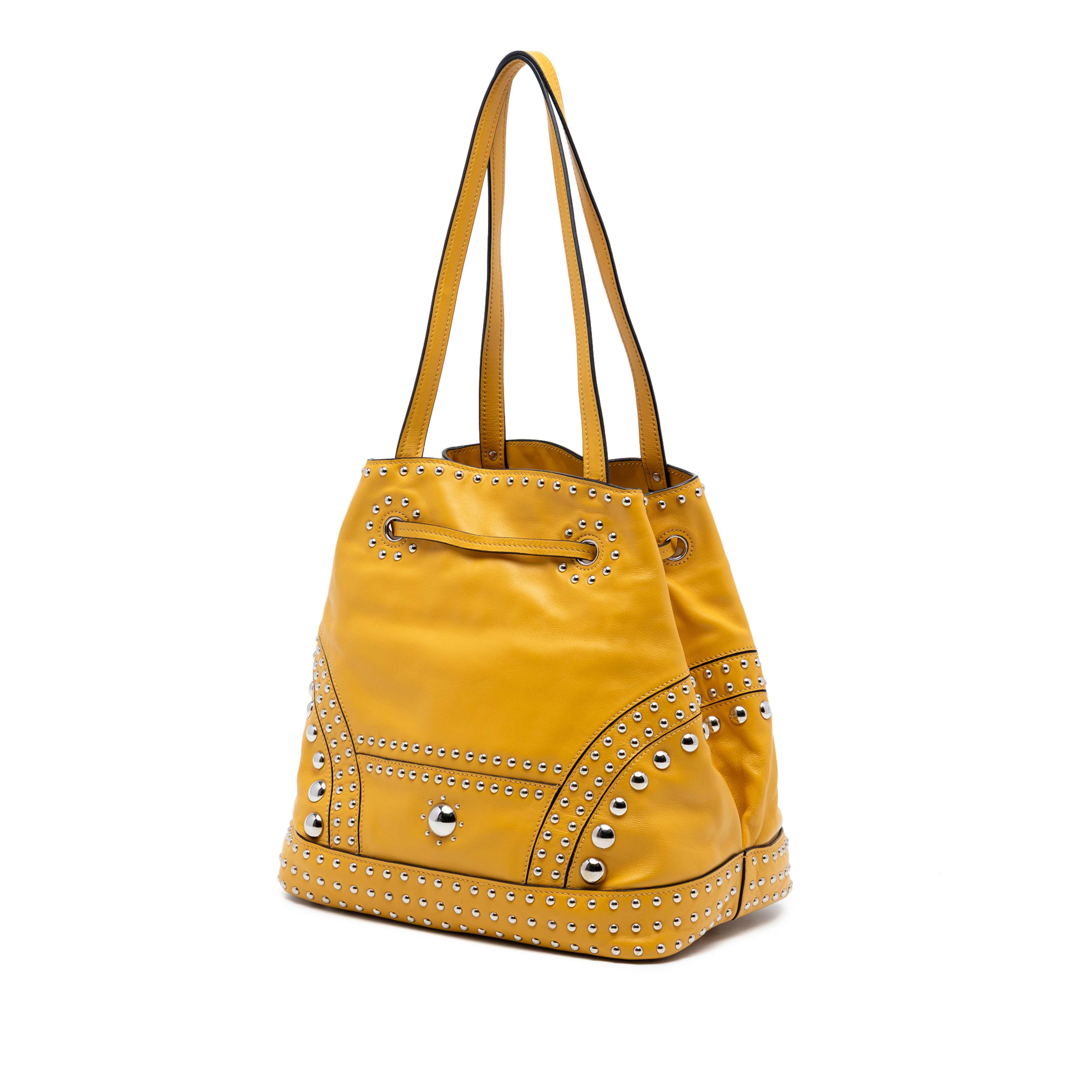 Prada Soft Calf Studded Bucket Bag, från Luxclusif, i färgen mustard. Klicka för att öppna bilden i stort format