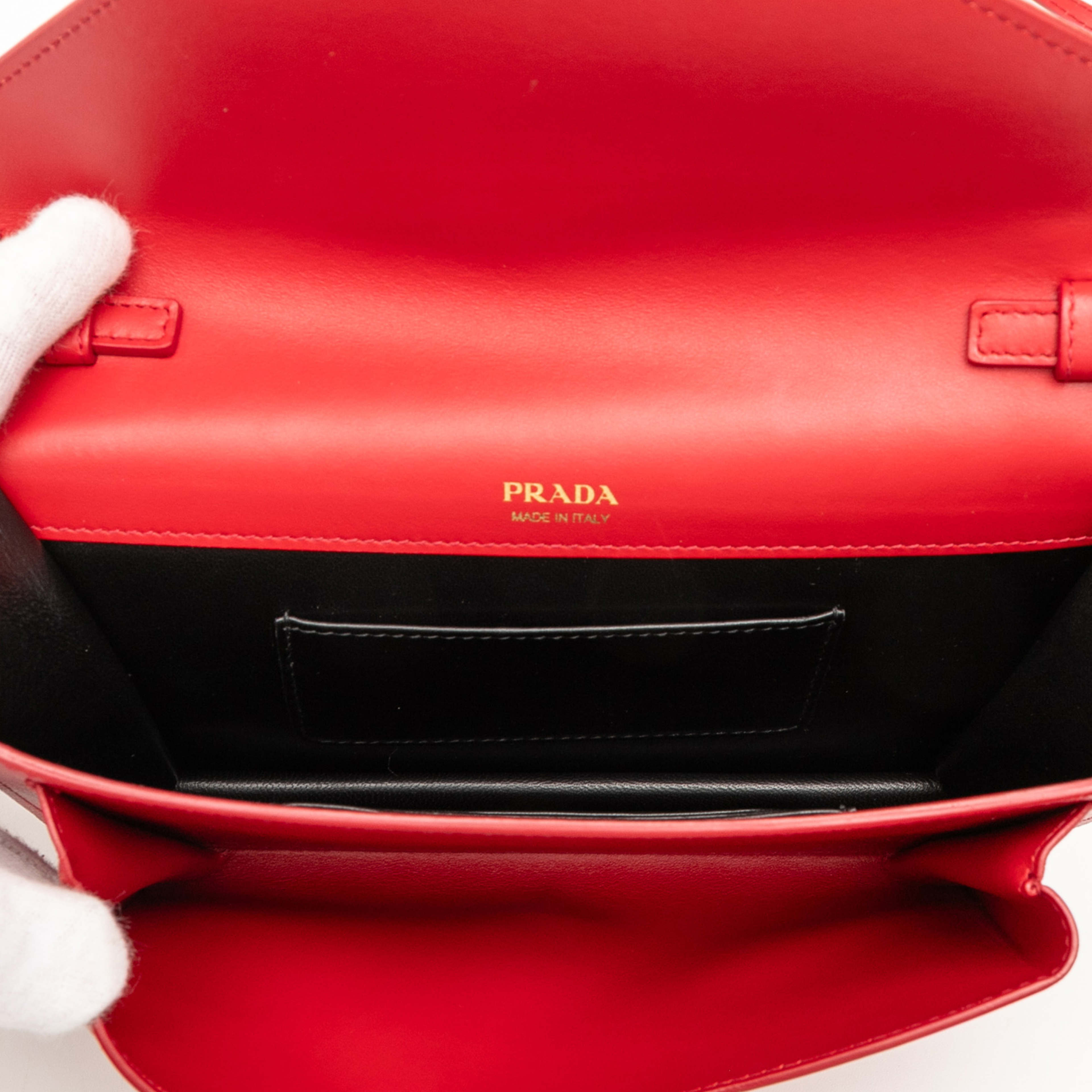 Prada Mini City Calf Trimmed Saffiano Monochrome Envelope Crossbody, från Luxclusif, i färgen red. Klicka för att öppna bilden i stort format