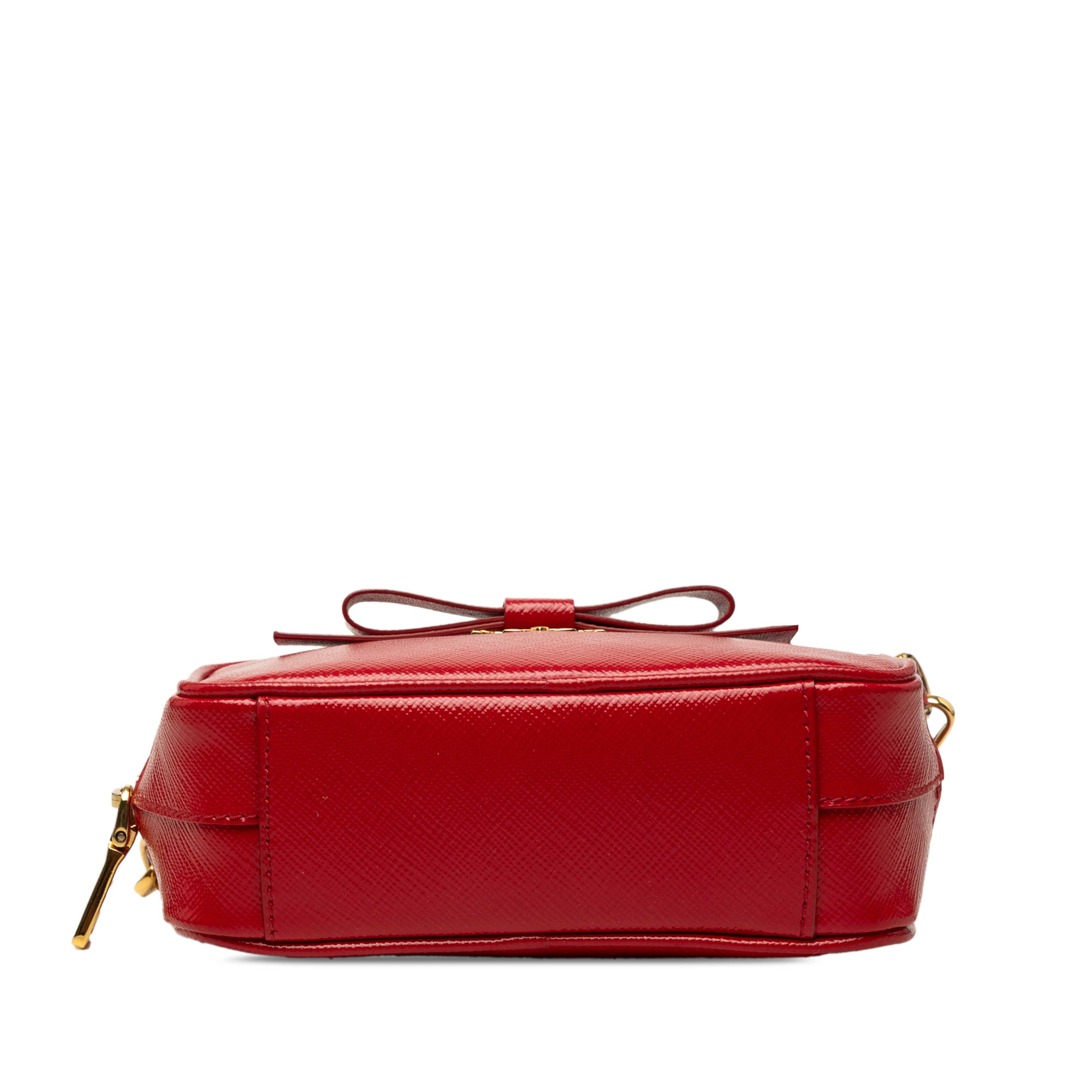 Prada Saffiano Vernice Bow Camera Bag, från Luxclusif, i färgen röd. Klicka för att öppna bilden i stort format
