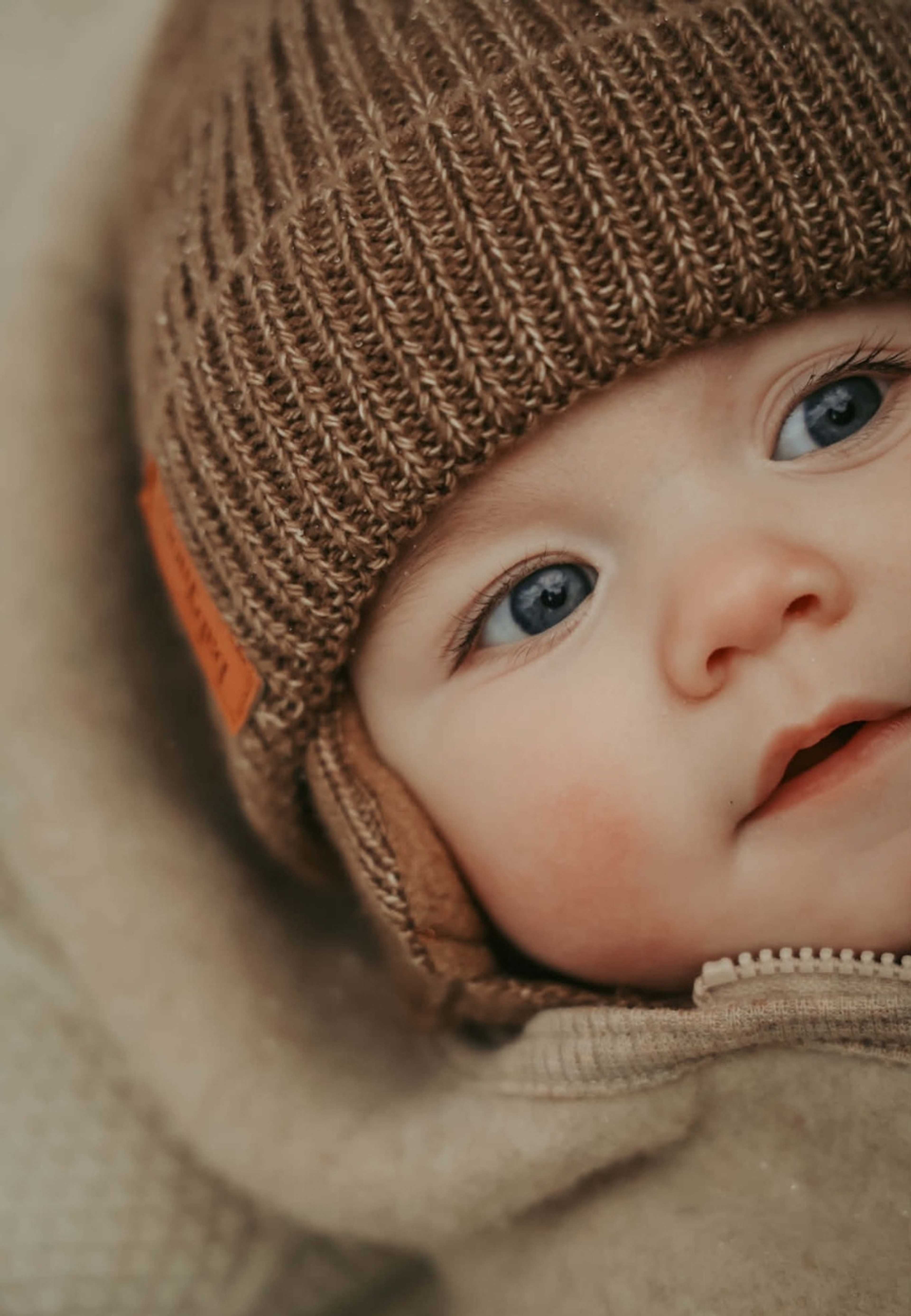 Earflap Beanie, från BabyMocs, i färgen caramel. Klicka för att öppna bilden i stort format