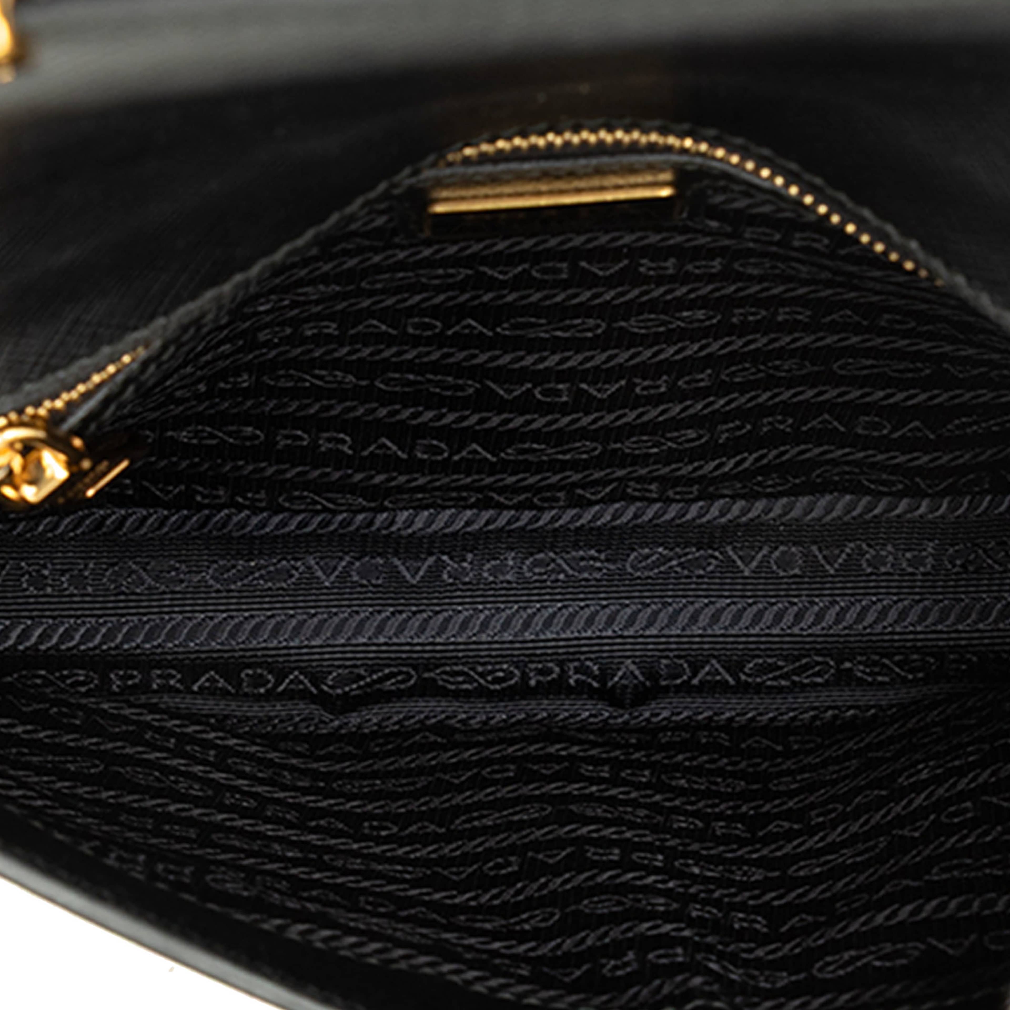 Prada Saffiano Push Lock Crossbody, från Luxclusif, i färgen svart. Klicka för att öppna bilden i stort format