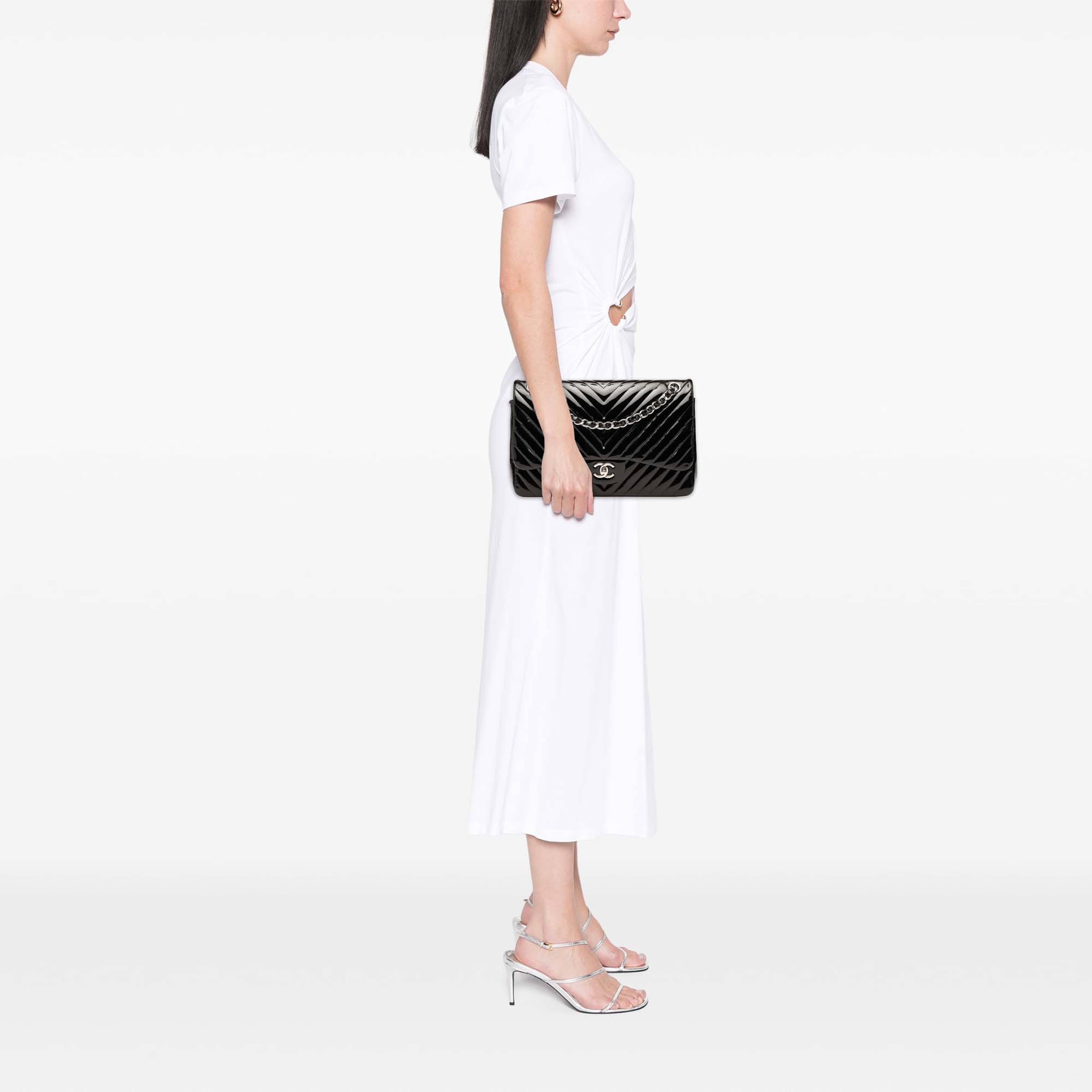 Chanel Jumbo Classic Chevron Patent Double Flap, från Luxclusif, i färgen svart. Klicka för att öppna bilden i stort format