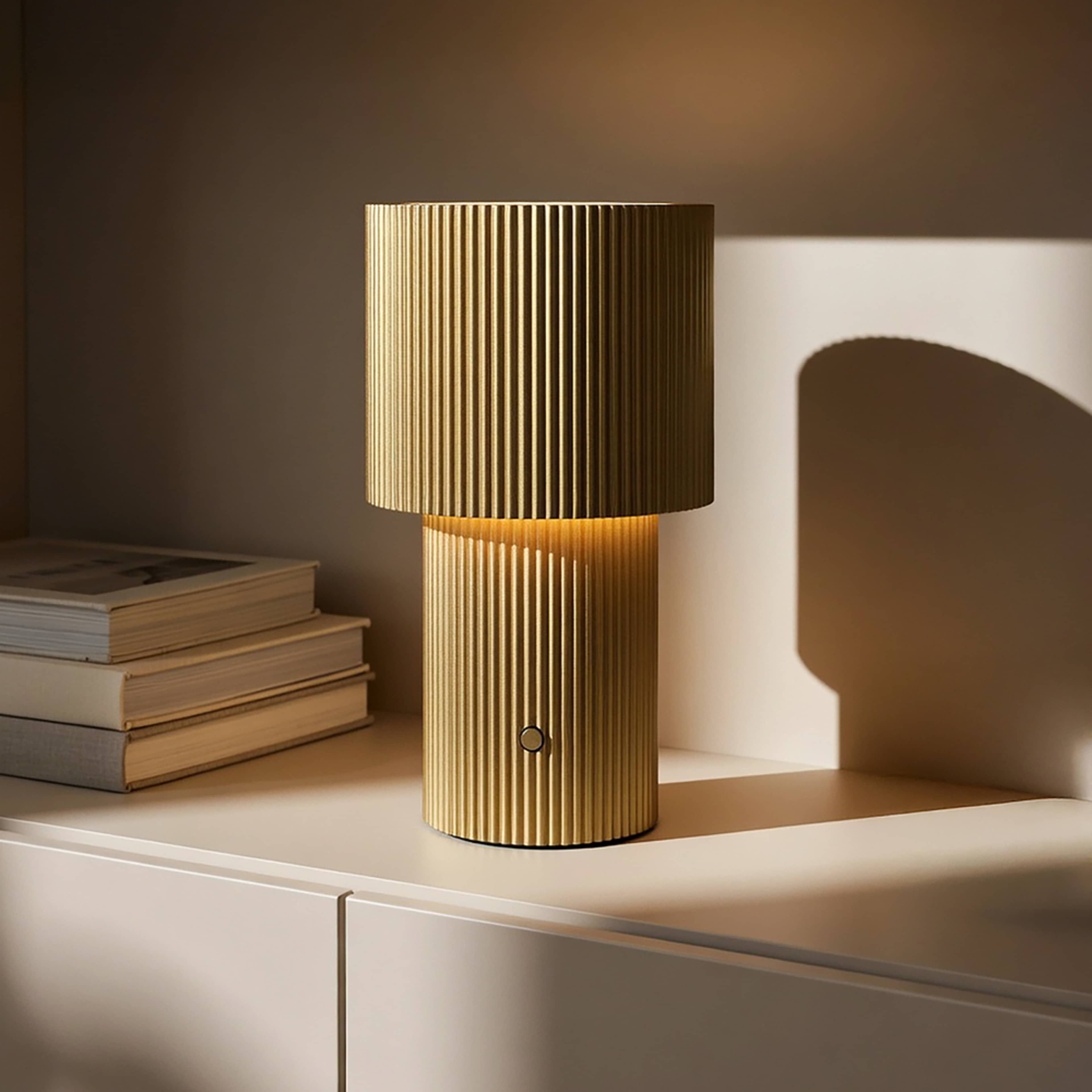 Bordslampa Iluma Portabel, från Herstal, i färgen guld. Klicka för att öppna bilden i stort format