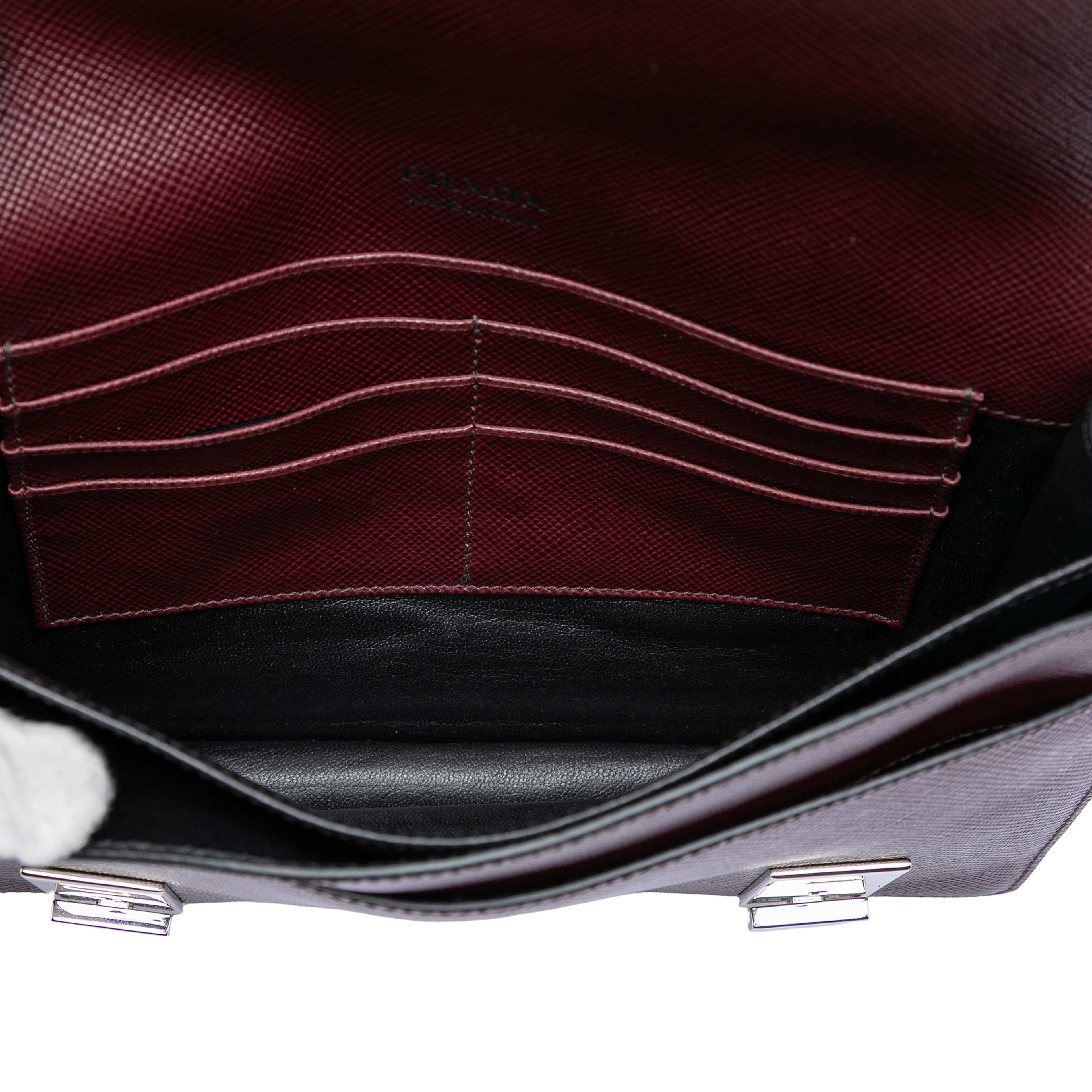 Prada Saffiano Double Lock Convertible Clutch, från Luxclusif, i färgen burgundy. Klicka för att öppna bilden i stort format