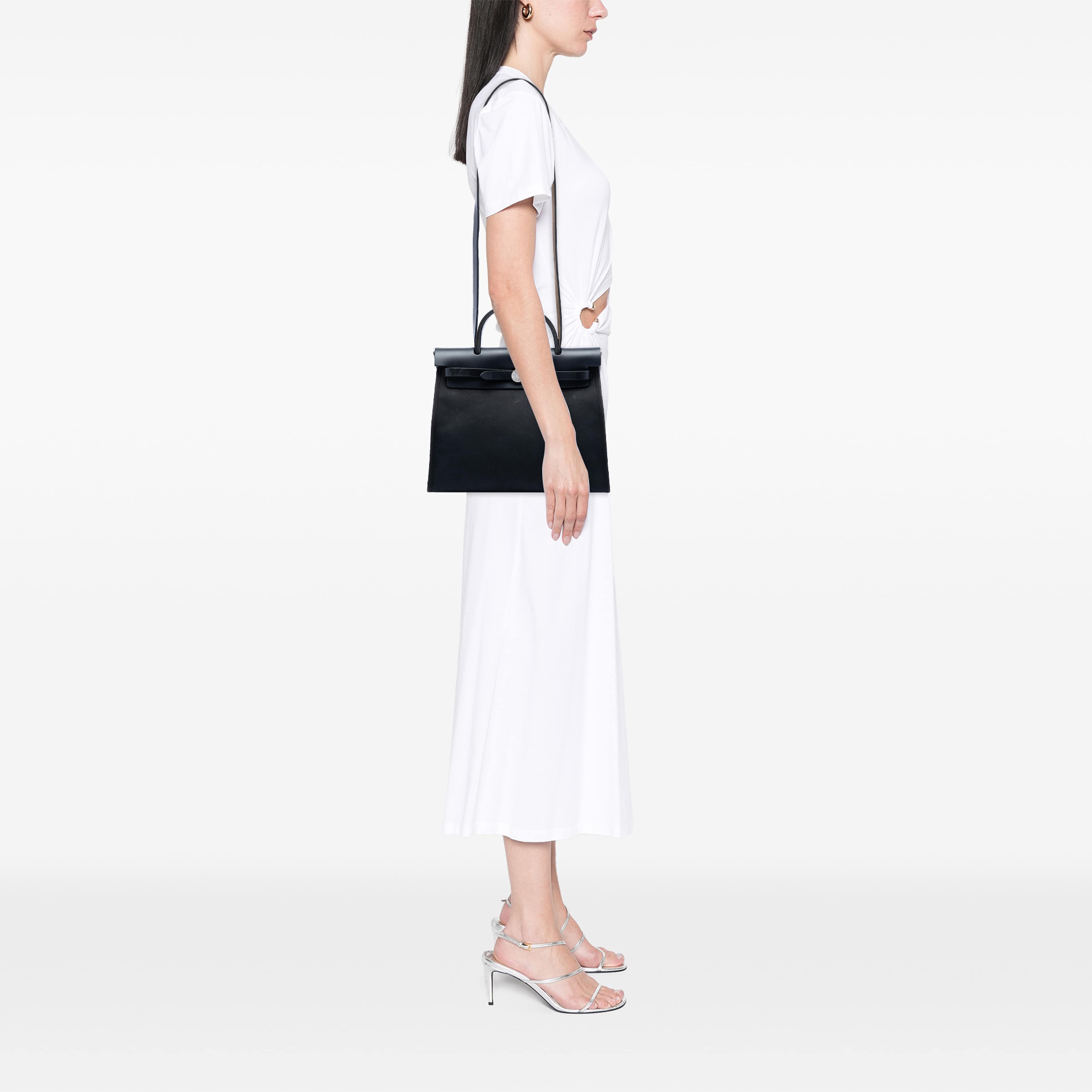 Hermès Toile H Berline Herbag Zip 31, från Luxclusif, i färgen black. Klicka för att öppna bilden i stort format