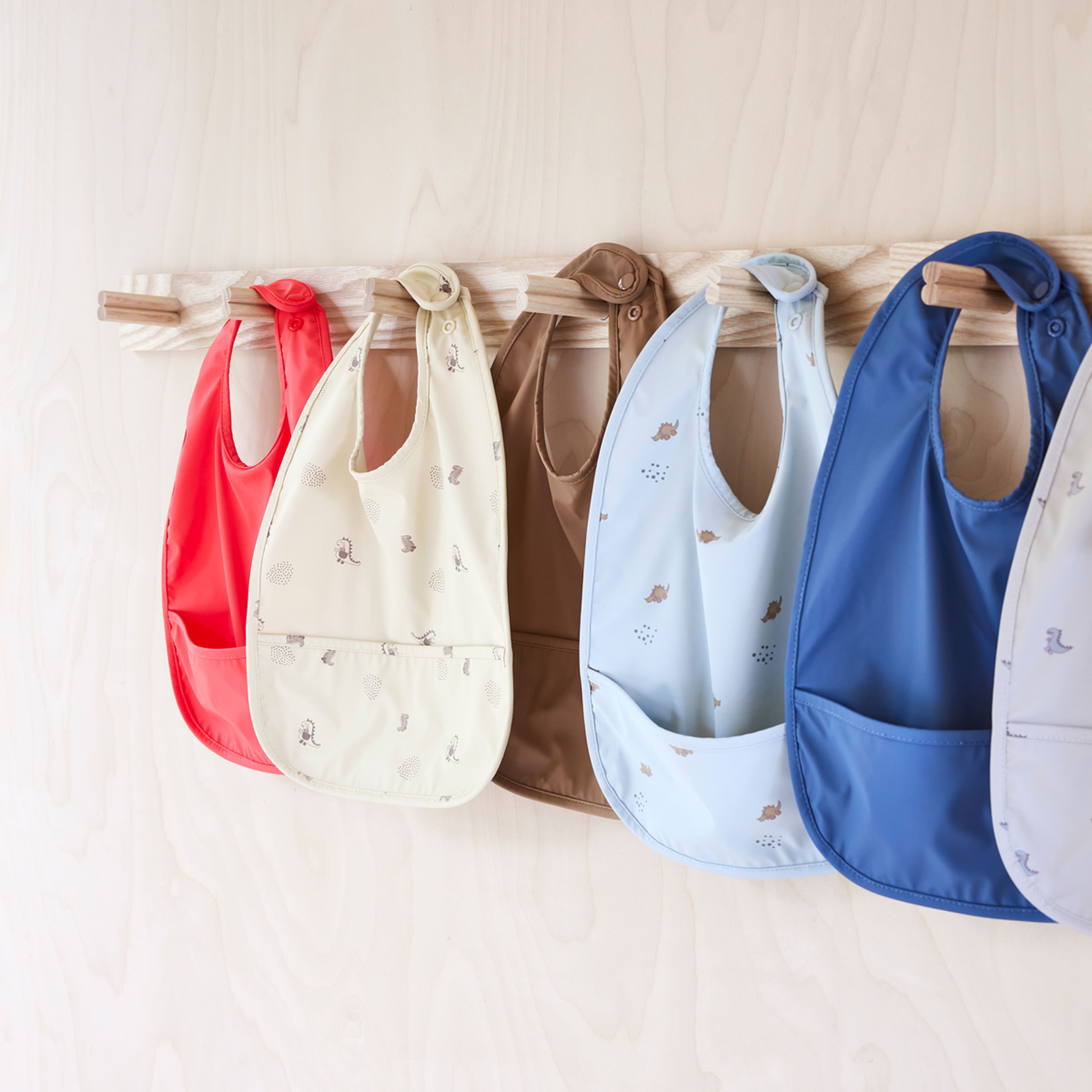 Dino Bib - Pack Of 2, från OYOY Mini, i färgen butter/cherryred. Klicka för att öppna bilden i stort format