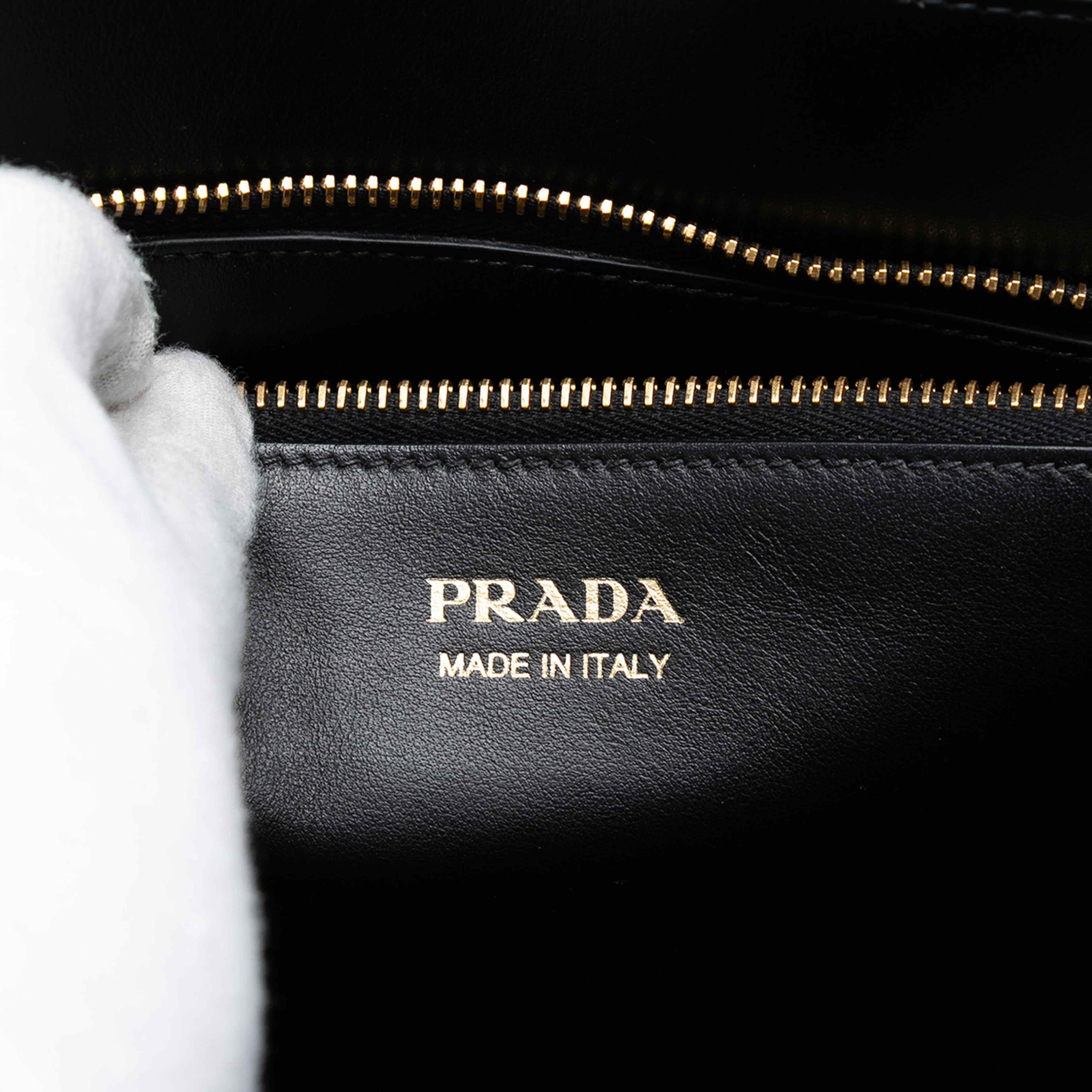 Prada City Calf Trimmed Saffiano Paradigme Whipstitch Satchel, från Luxclusif, i färgen black. Klicka för att öppna bilden i stort format