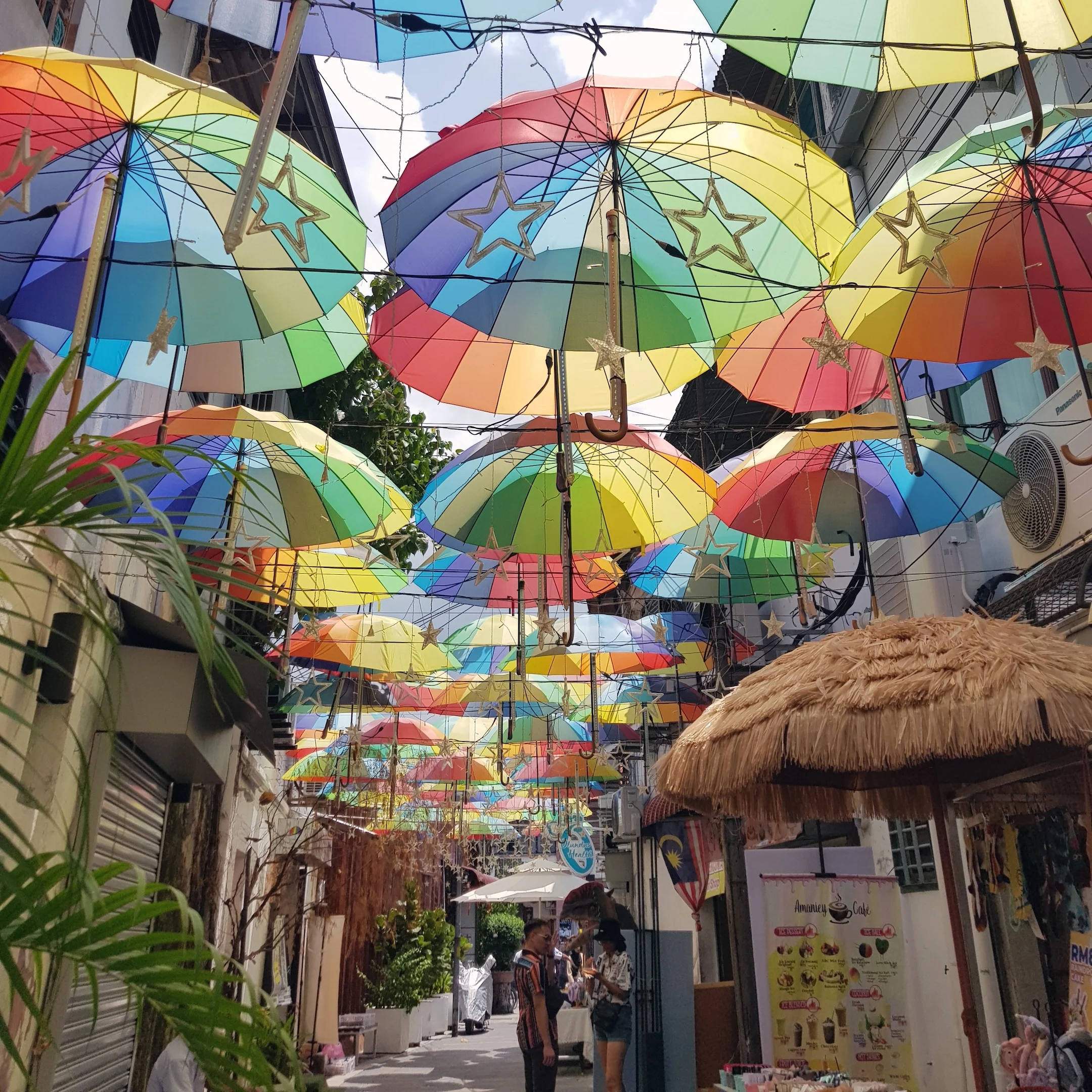 A street with umbrellas hanging from the ceiling.