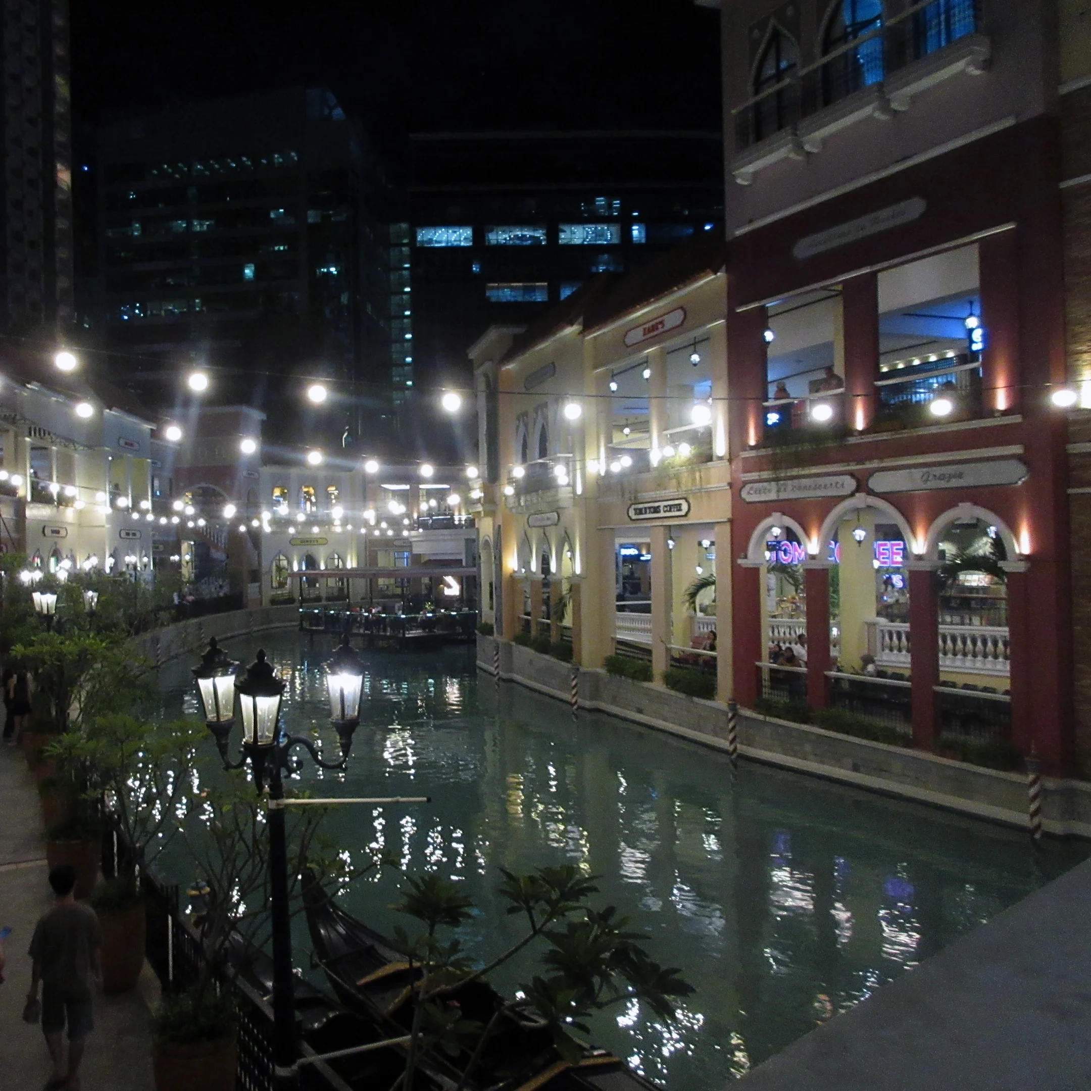A canal in a city at night time.