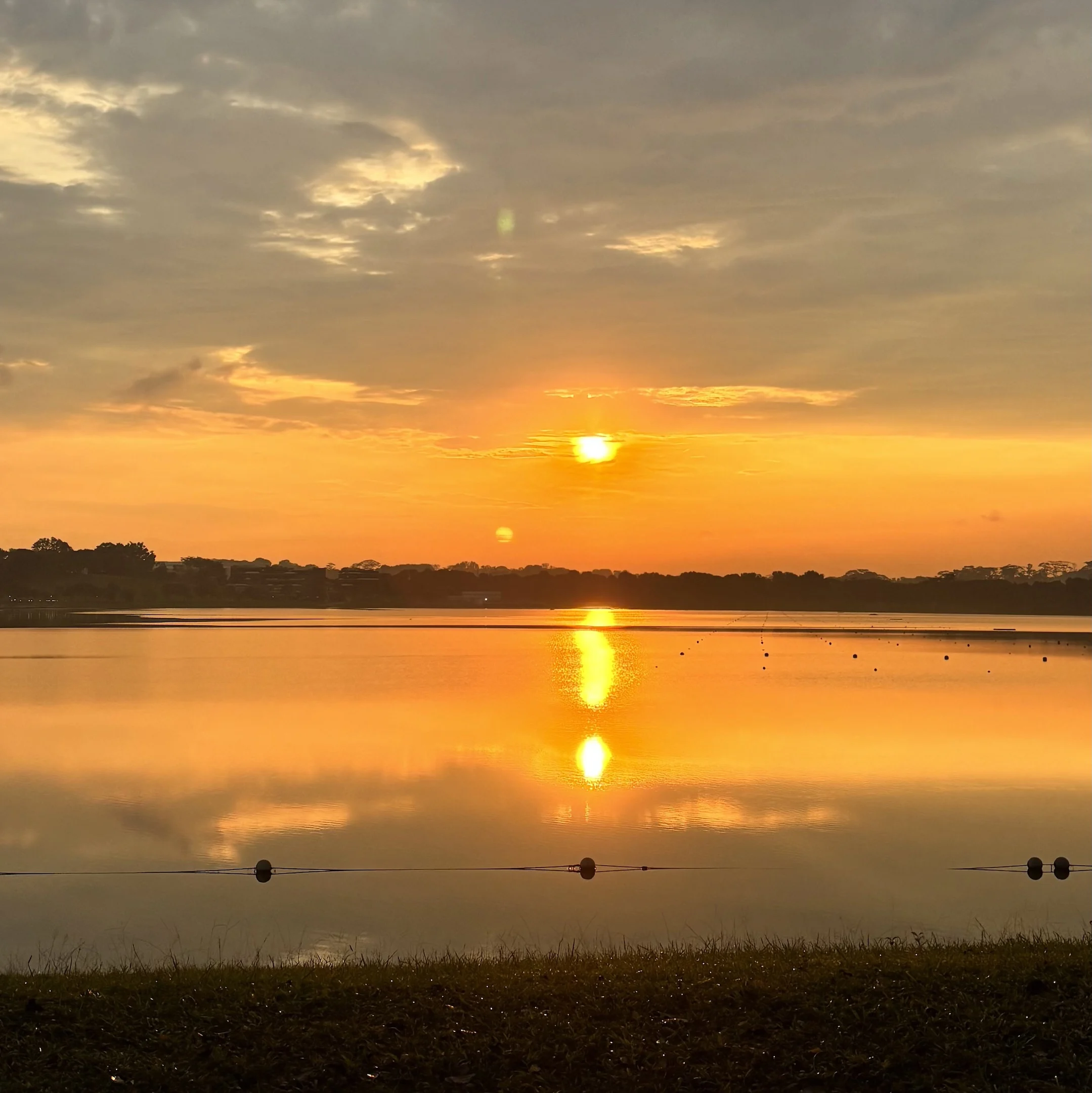 A man sitting on a bench watching the sunset.