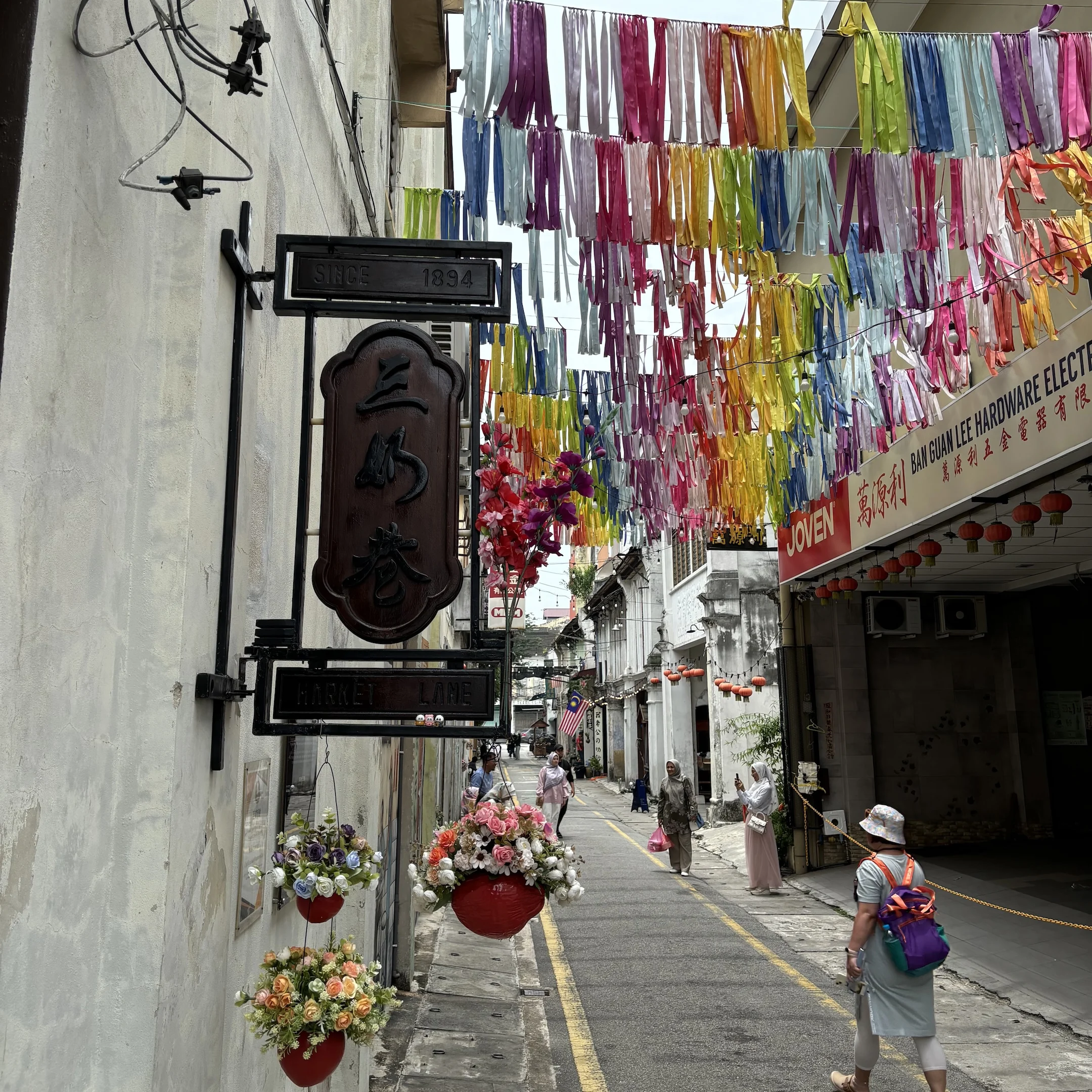 A woman walking down a street with a bunch of flowers.
