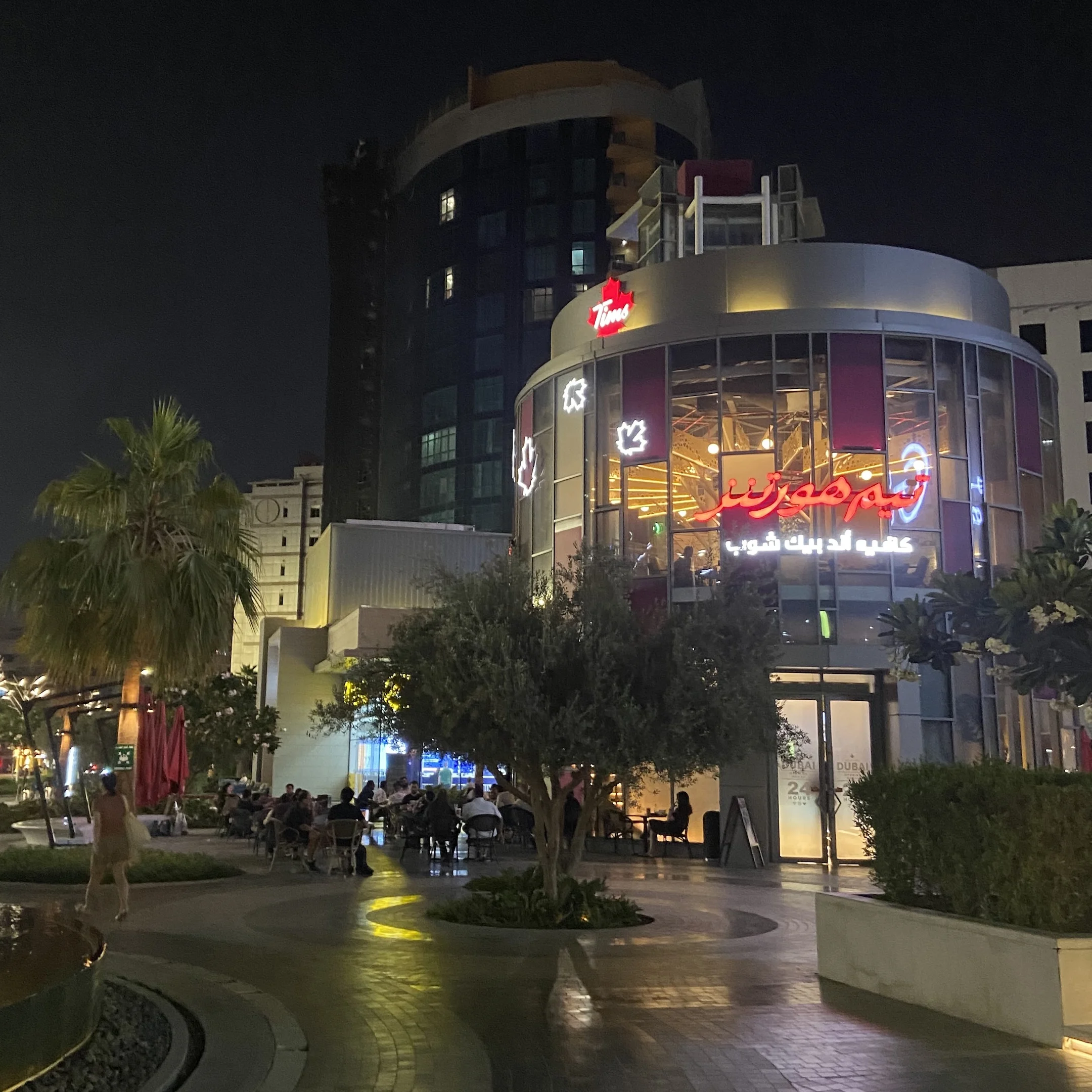A city street at night with a large building.