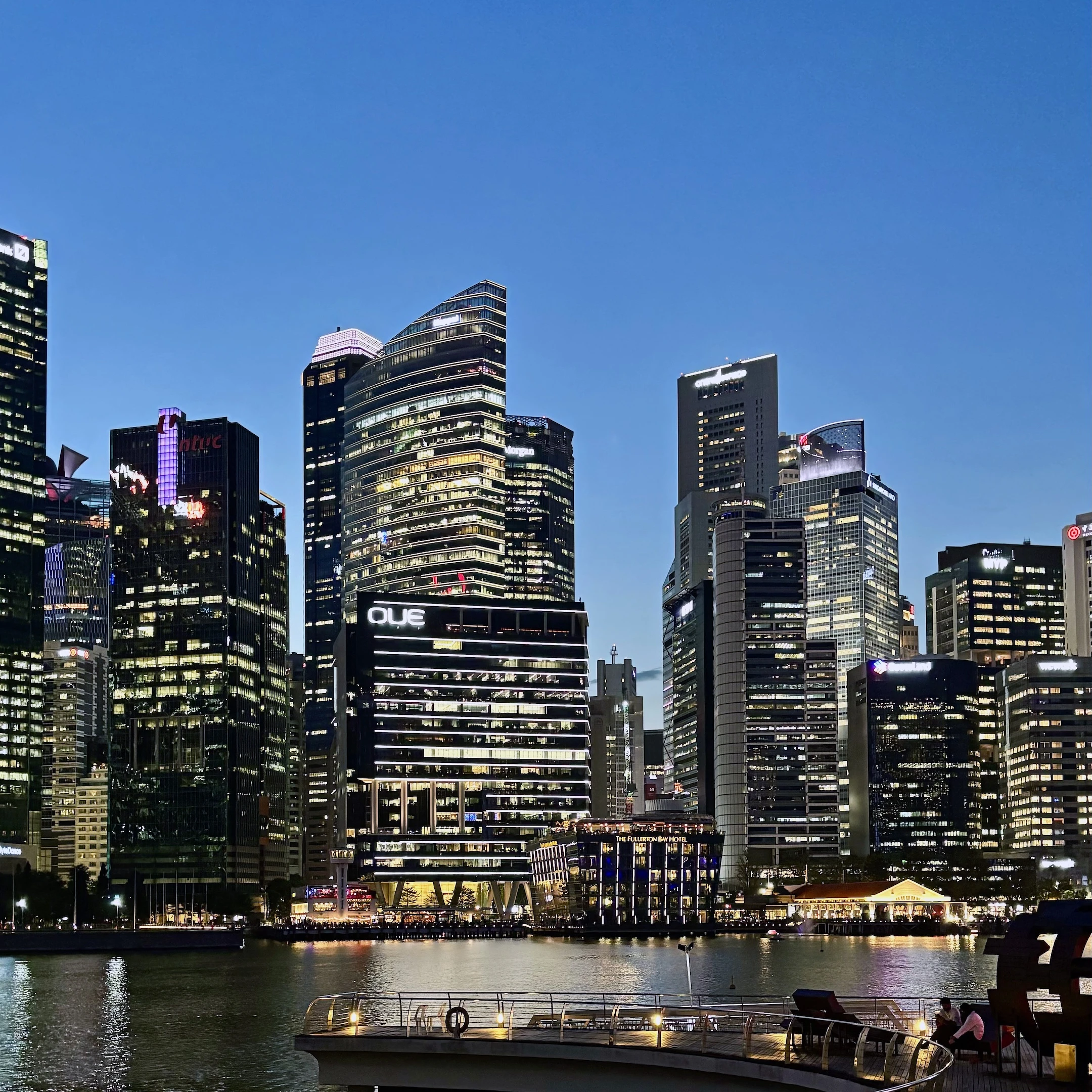 A boat is docked in a harbor with a city skyline in the background.