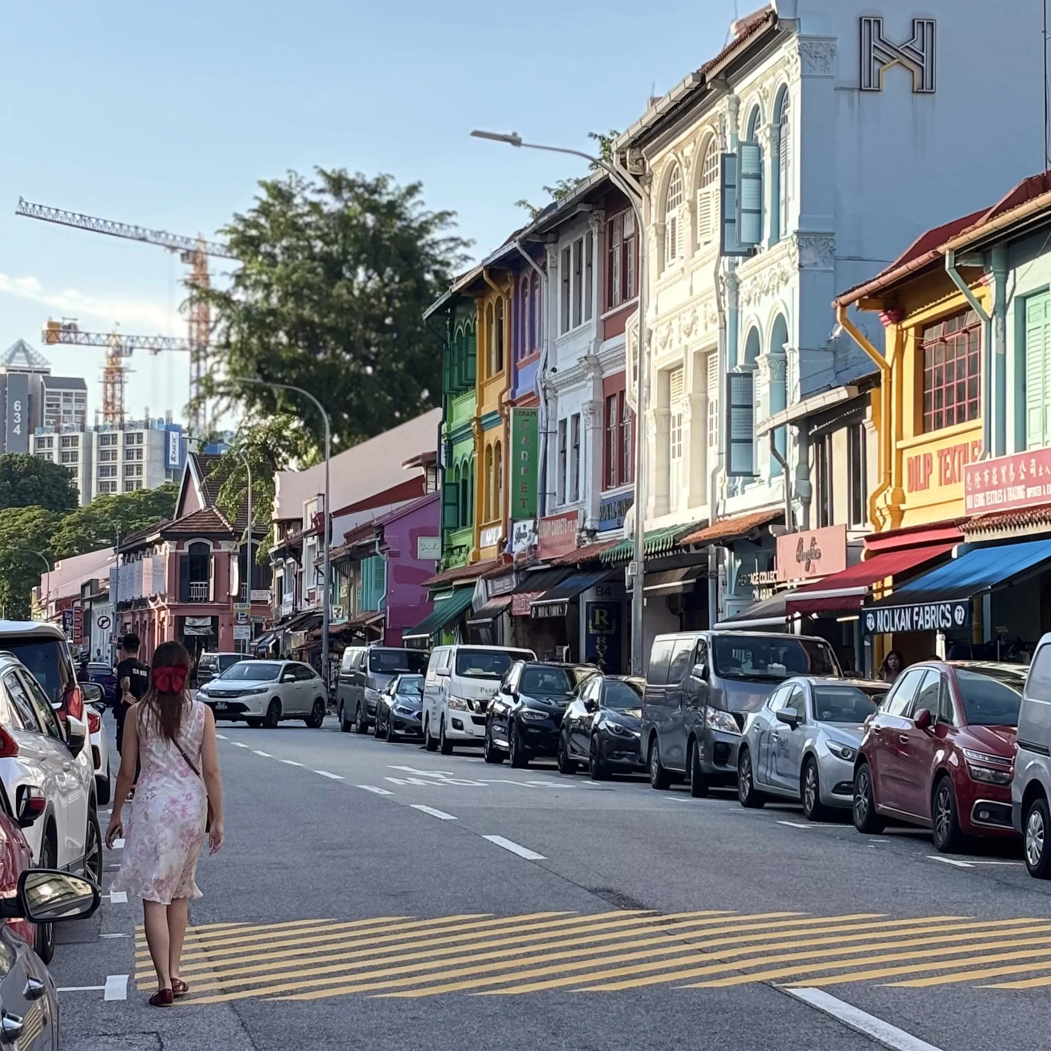 A woman walking down a street in a city.