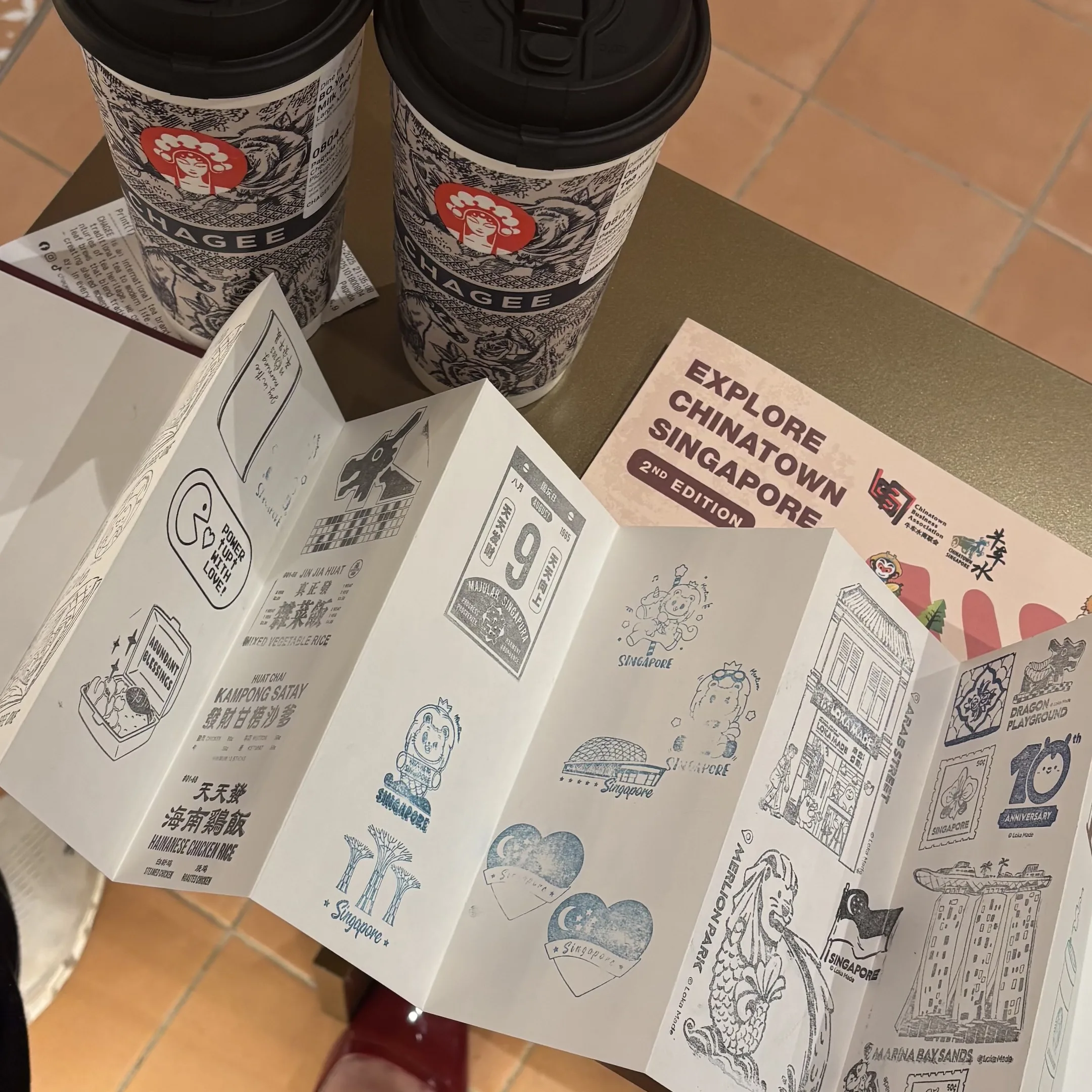 A coffee cup and a book on a table.