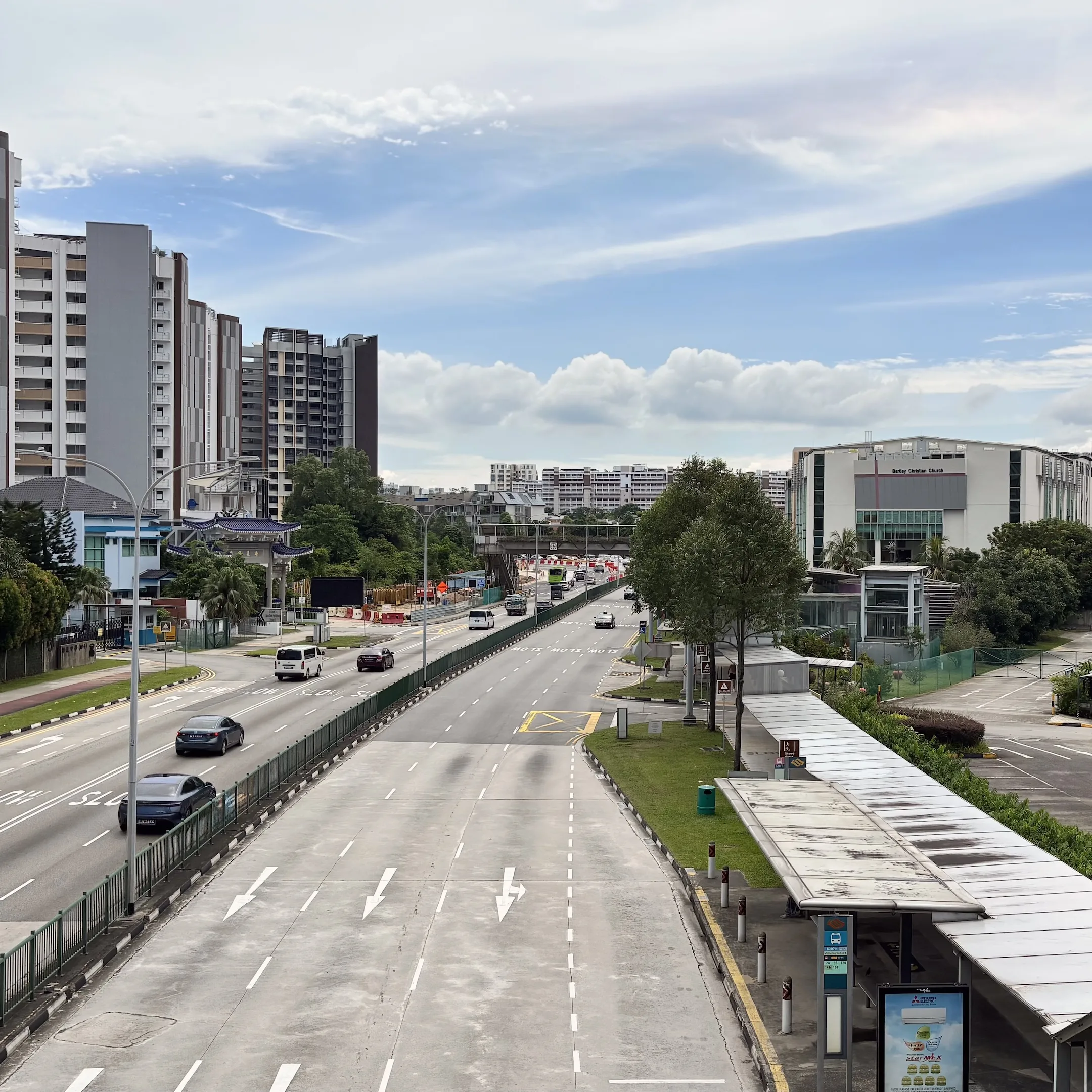 A city street with a bus and a bus stop.