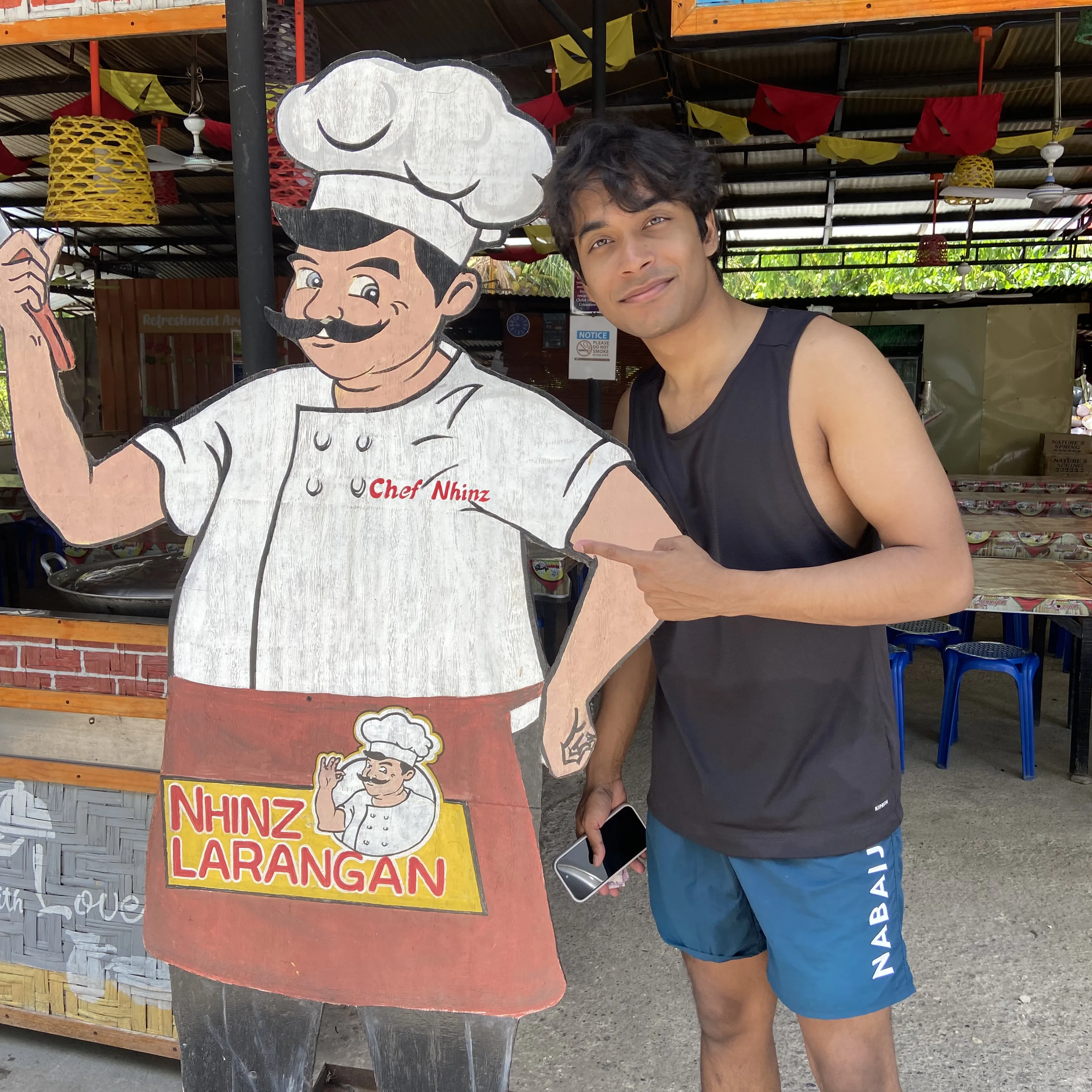 A man standing next to a sign with a chef.