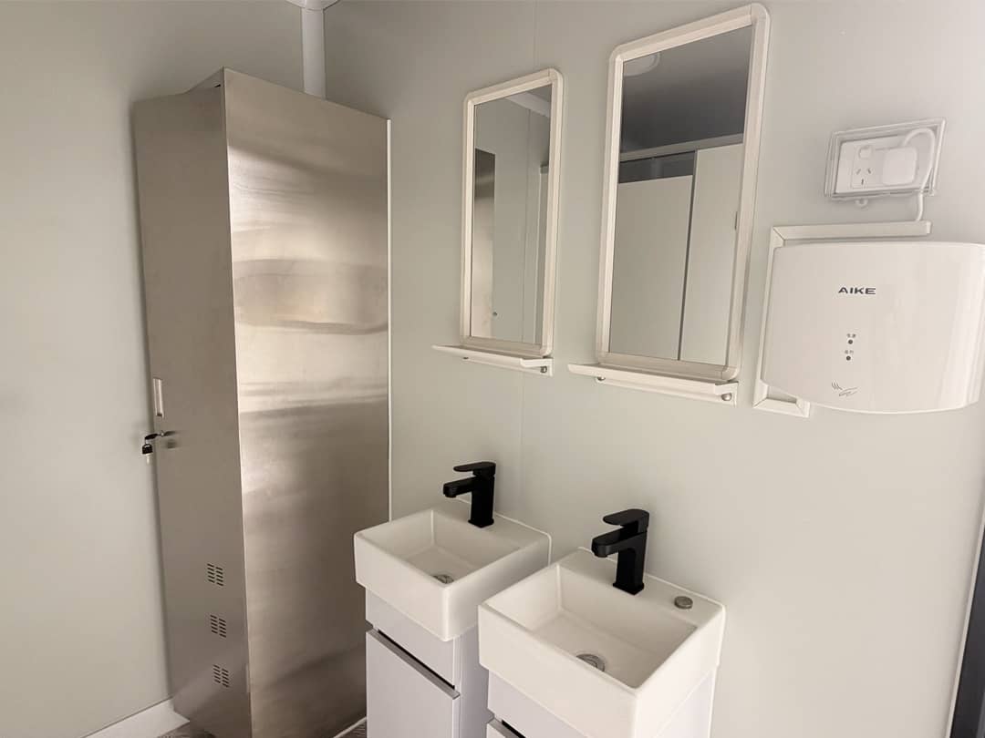 Interior wash area of a container ablution block with twin basins, mirrors and hand dryer