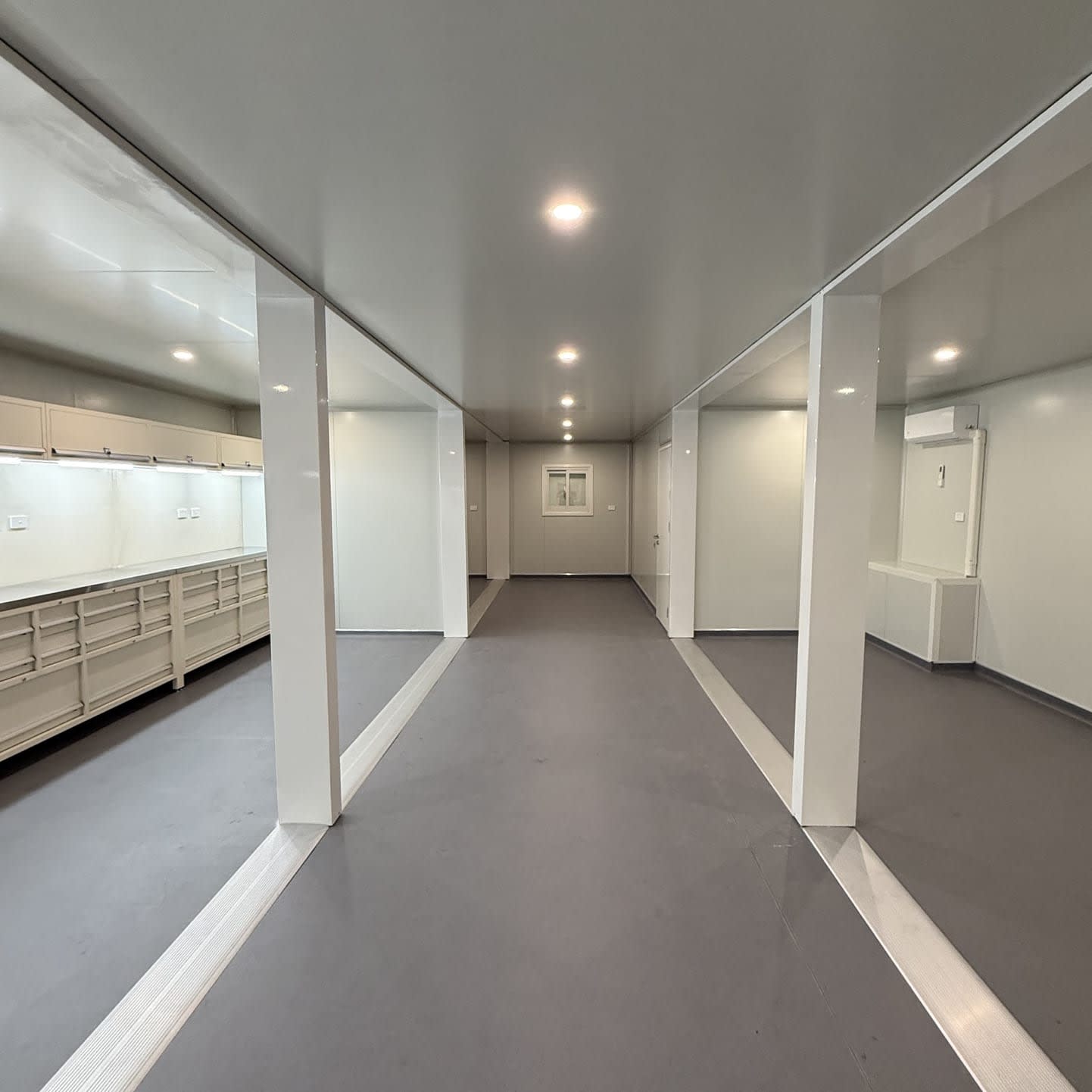Open-plan interior of a container kitchen and mess building with fitted bench units and vinyl flooring