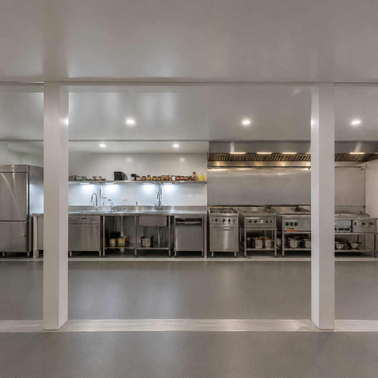Commercial kitchen interior in a container mess facility with stainless steel benches and cooking equipment