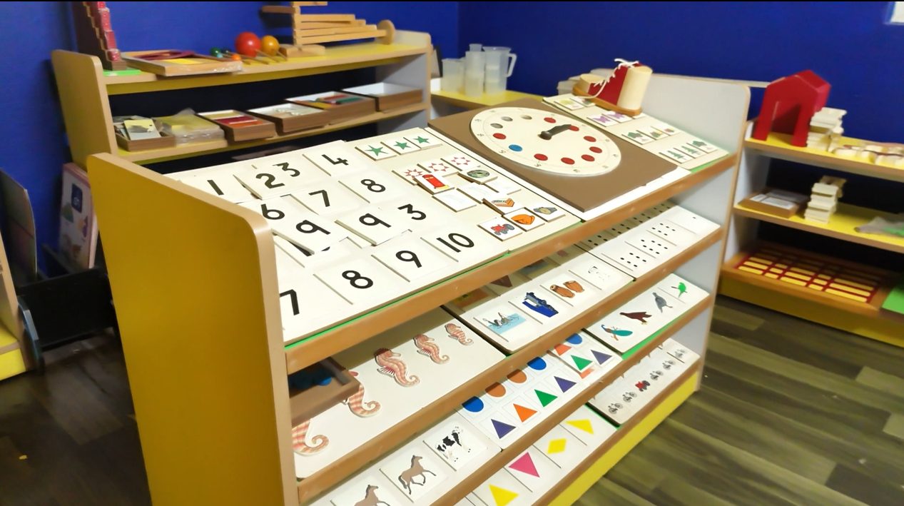 Students playing soccer on a grassy field in the evening.