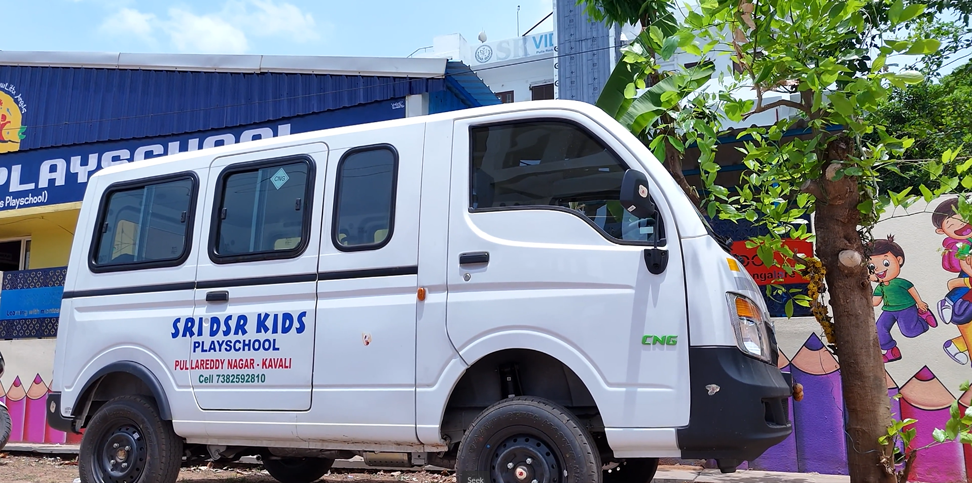 Students in uniforms standing outside the school entrance.