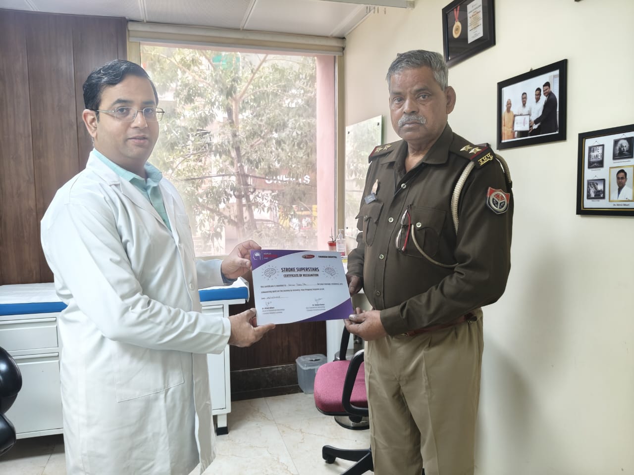 Dr. Ritwiz Bihari presenting Stroke Superstar Certificate to a Police Officer at Chandan Hospital
