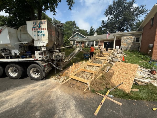 Concrete mixer truck and crew forming a new walkway