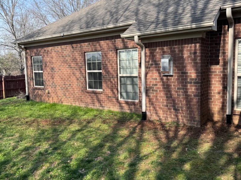 Downspouts tied into underground drains along a brick home's foundation in Huntsville