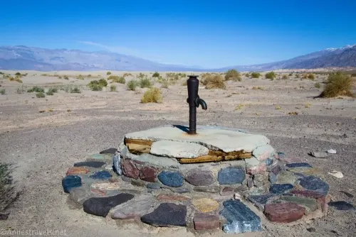 An old pump set in stones and concrete on a desert plain 