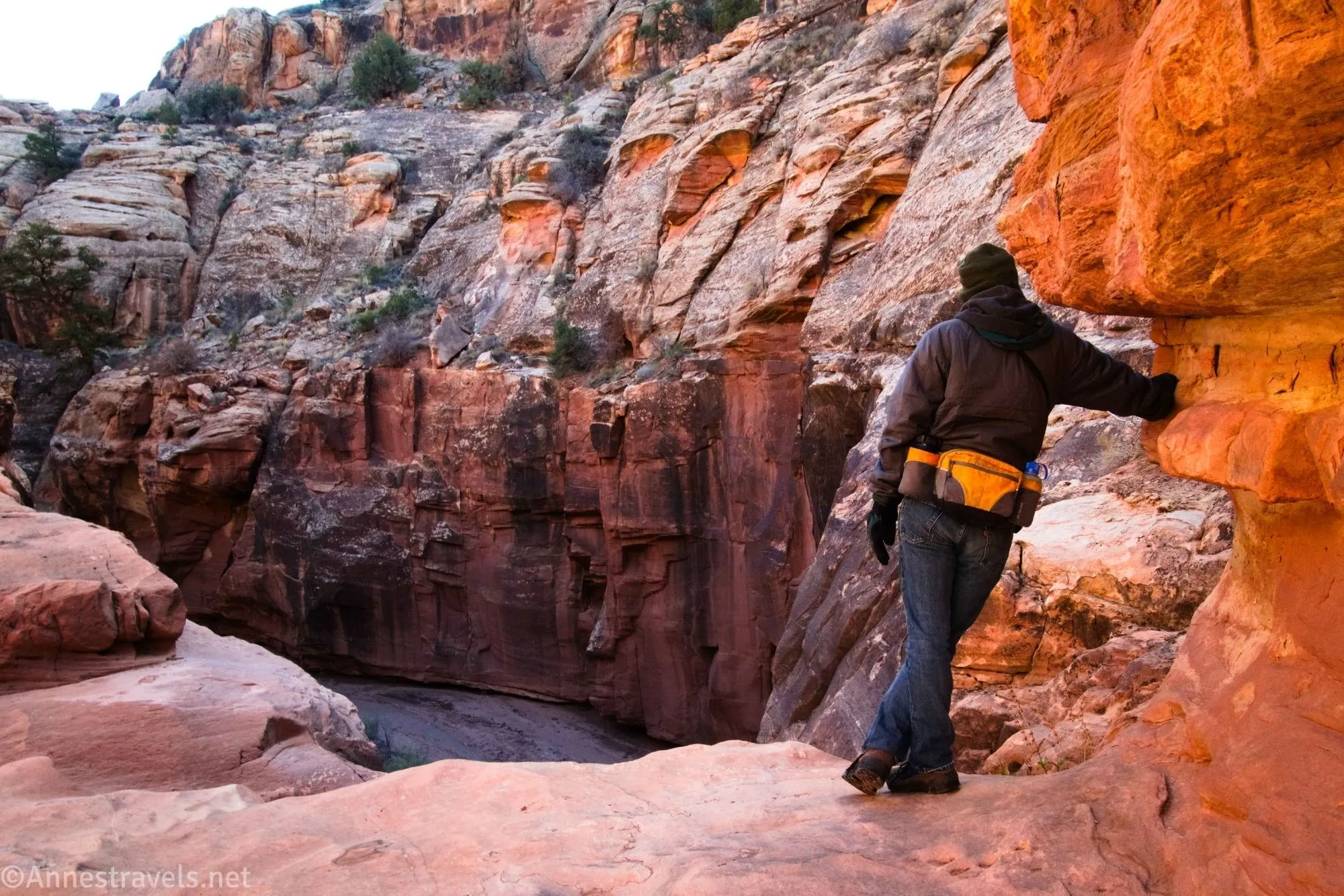 Standing at the brink of the large dryfall that stops casual downcanyon progress in Cove Canyon, Maze District of Canyonlands National Park, Utah