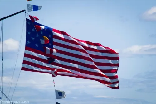 A historic American flag with blue sky and clouds behind it