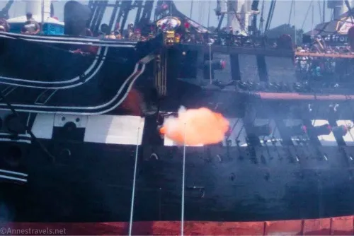 Fire blasts out of a cannon in a historic warship in Boston Harbor